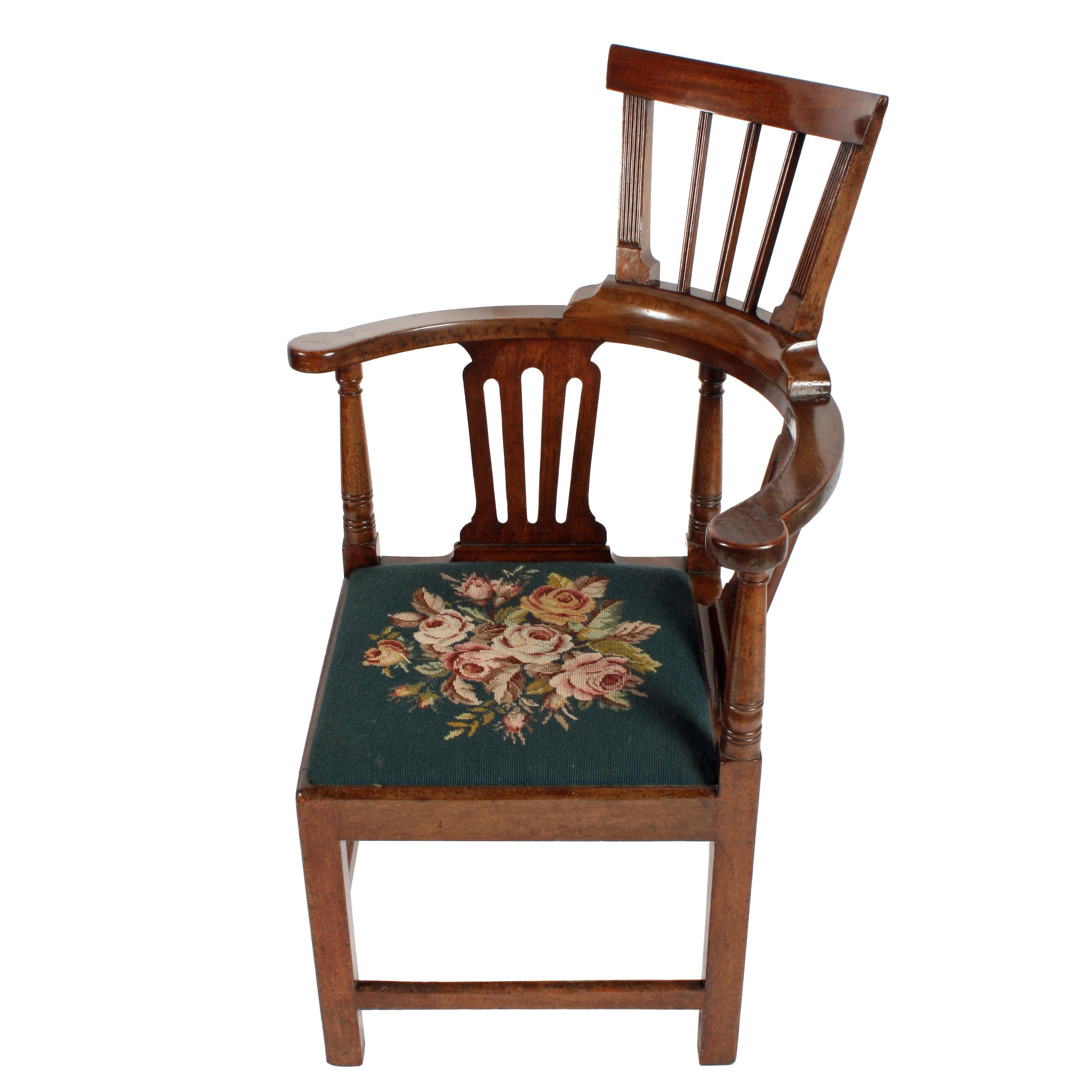 An 18th century mahogany corner armchair.

The chair has a high comb back with four square legs that have cross rails between and a drop in needlework upholstered pad seat.

The chair has three turned supports and two pierced splats forming the