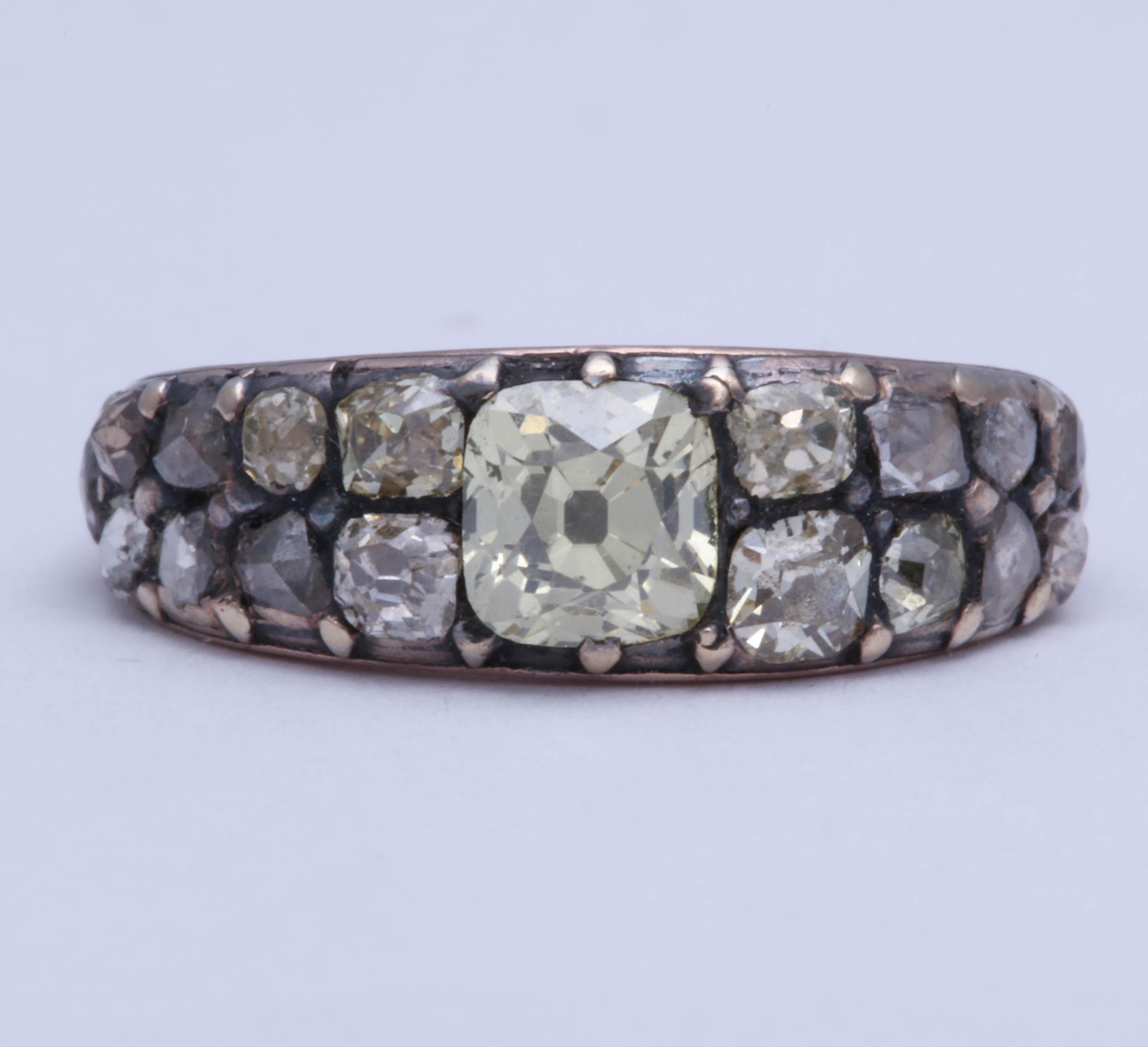 The diamonds, totaling 18 old mine and rose cuts, are set in silver over 18K yellow gold. Closed back setting. 