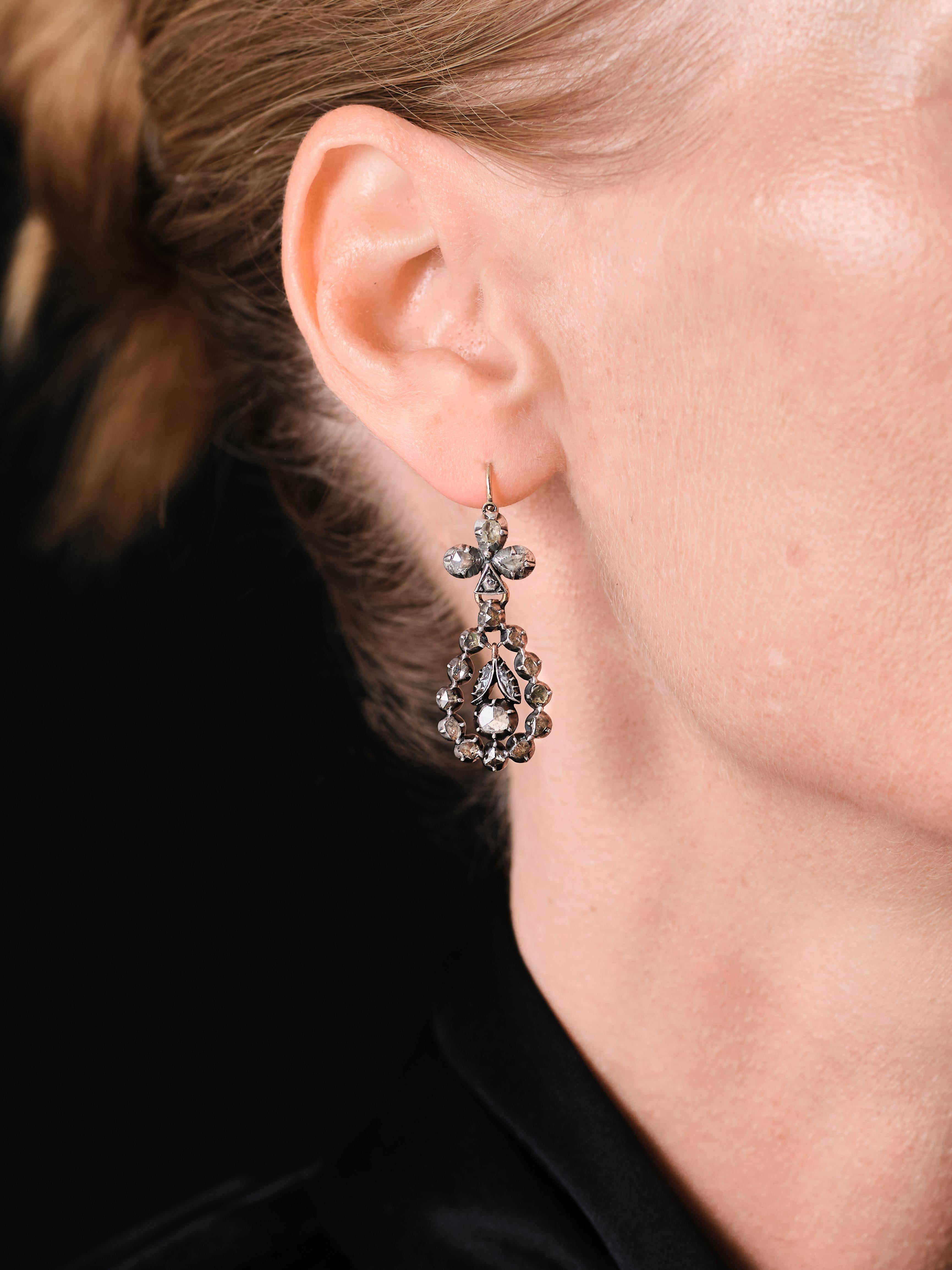 A pair of 18th century georgian / early Victorian rose cut fleur de lis night/day earrings diamond pendant earrings comprised of a round-shaped diamond in a surrounding frame and suspended from a “fleur de lis” motif surmounts. 

Day and night