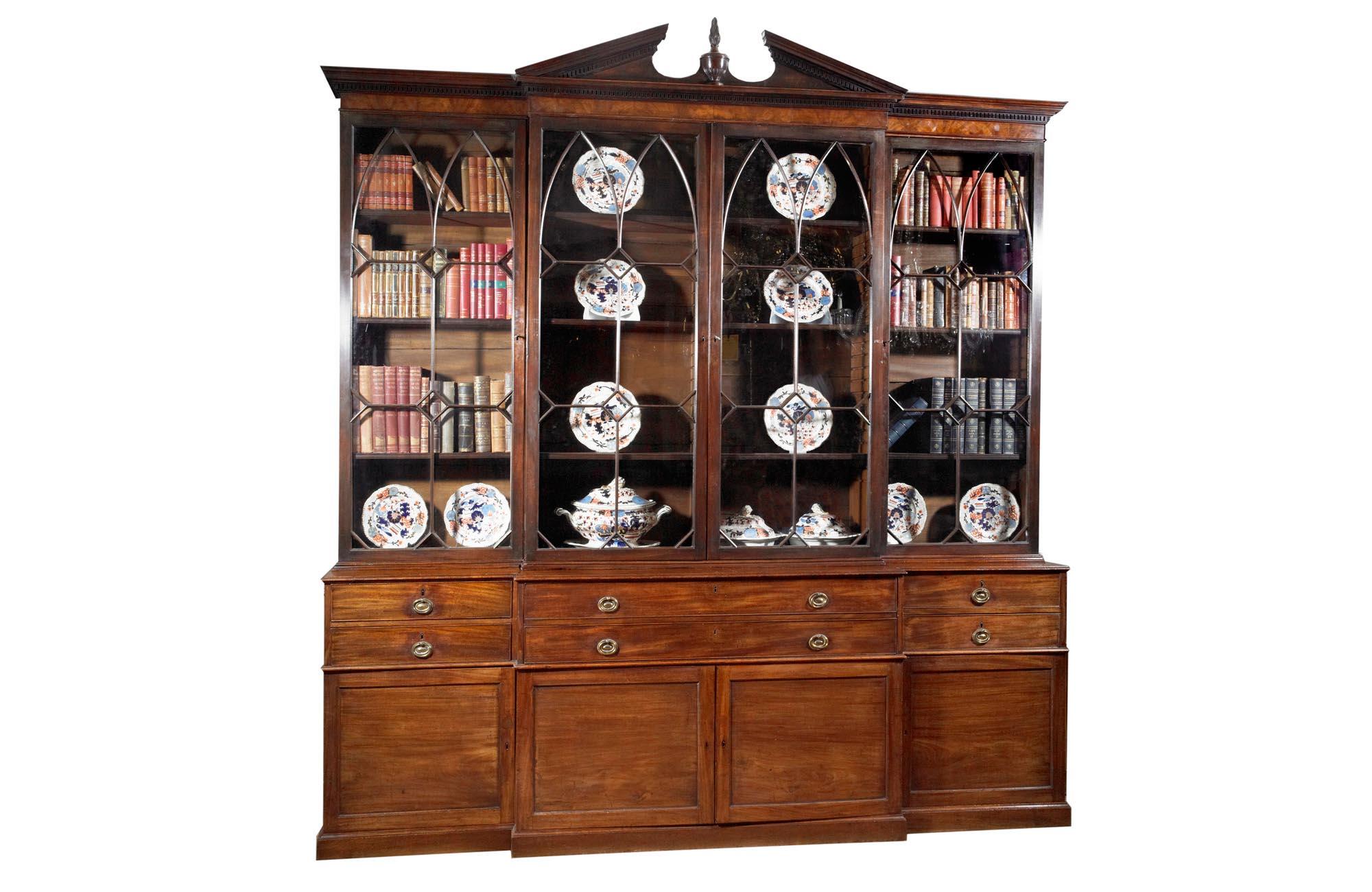 18th Century George III mahogany secretaire breakfront bookcase, with four astragal glazed doors below dentil frieze and broken pediment with two long drawers above two central cupboard doors flanked by two short drawers and single cupboard doors on
