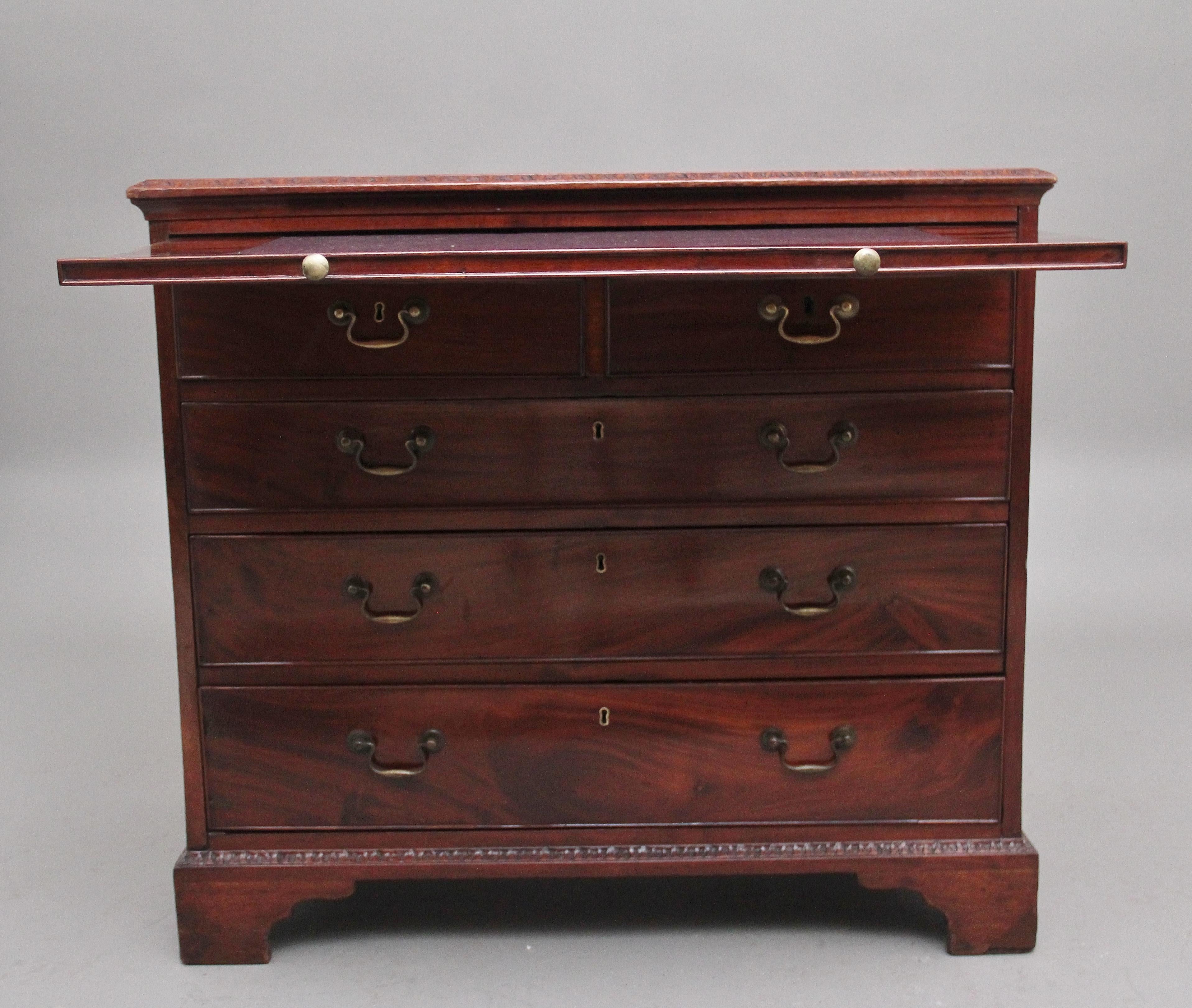 18th Century Georgian mahogany chest of drawers, having a nice figured top with a carved moulded edge above a brushing slide, two short over three long oak lined graduated drawers with the original brass swan neck handles, further carved decoration