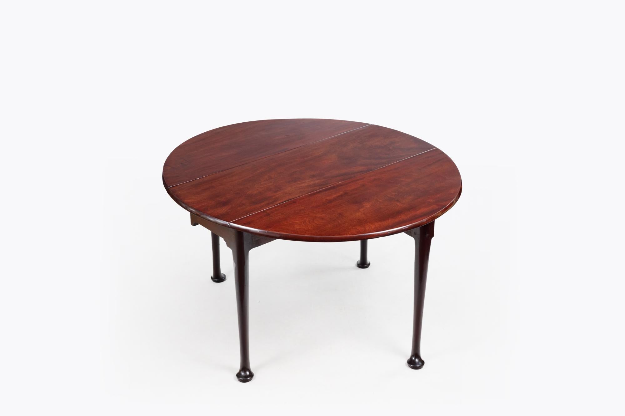 18th Century Georgian Mahogany Oval Drop-Leaf Table. The two ends lift up and are supported by solid mahogany gate legs to create a good-sized oval shape table top. Terminating With Original Pad Feet. Circa 1760.
