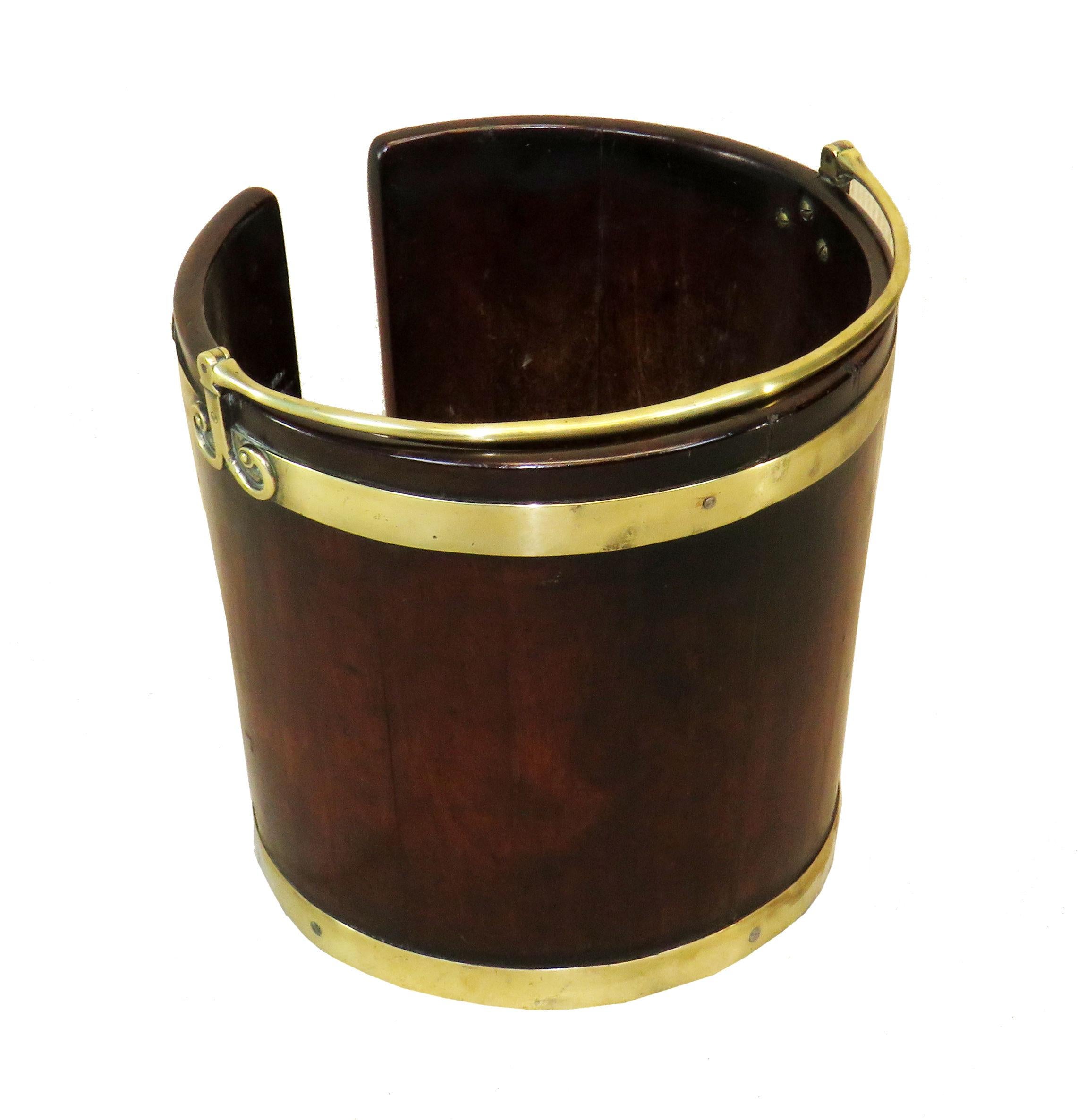 18th Century (1790s, Georgian Period) English mahogany plate bucket with original pivoting brass handle. This bucket would originally have been made to stand in the dining room and house a pile of plates, hence hole cut out of one side, to allow a