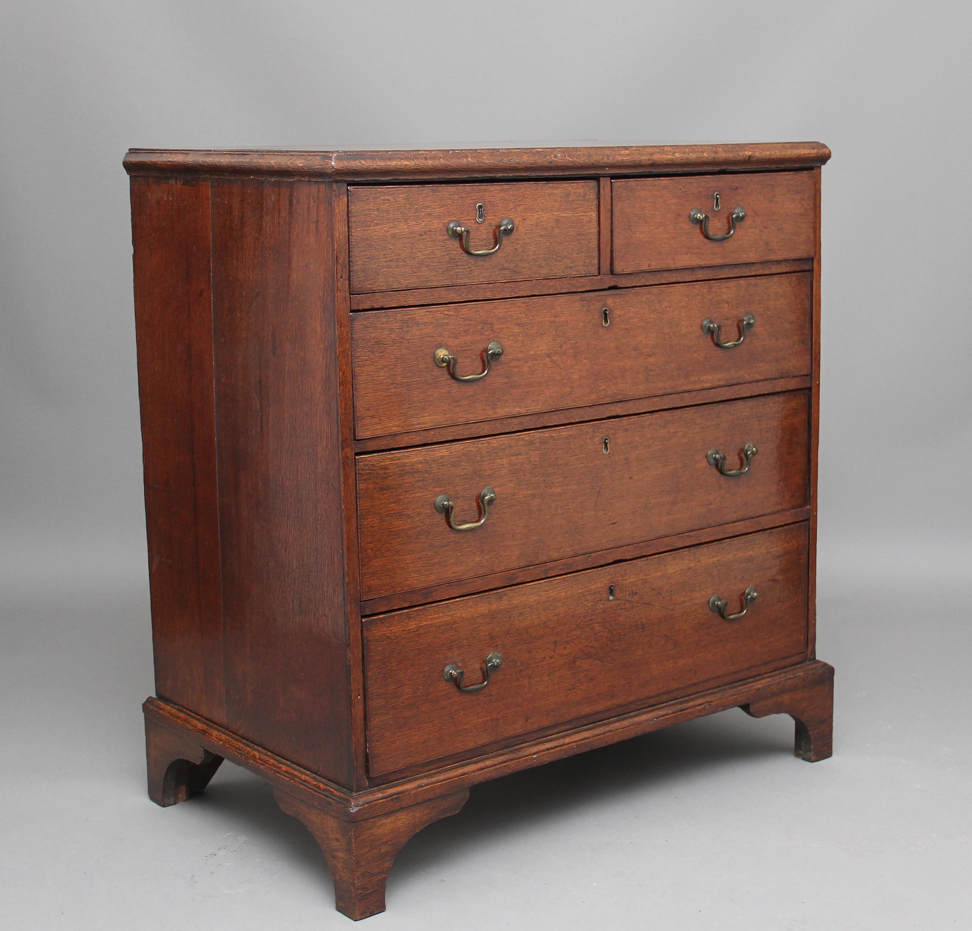 18th century Georgian oak chest, the moulded edge top above two short over three long, oak lined graduated drawers with original brass swan neck handles, standing on bracket feet, circa 1780.