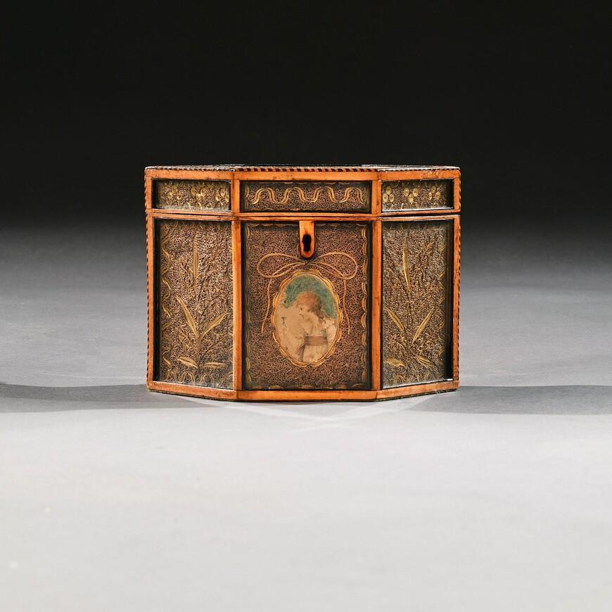 Magnifique boîte à thé en forme d'hexagone, datant du XVIIIe siècle et réalisée en style George III.

Anglais vers 1790

Finement exécuté, ce très joli caddy de forme hexagonale en bois de satin présente des panneaux glacés et décorés de volutes