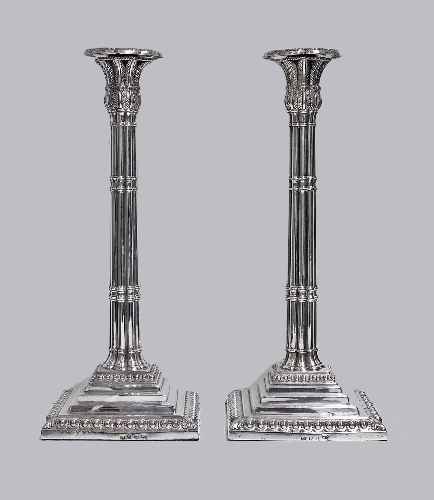George 11 silver candlesticks, London 1759 John Carter. The loaded Candlesticks of Corinthian column-form, stepped bases with upper and lower ovolo borders, bamboo style stems, acanthus anthemion like sconces, removable gadroon border nozzles. Full