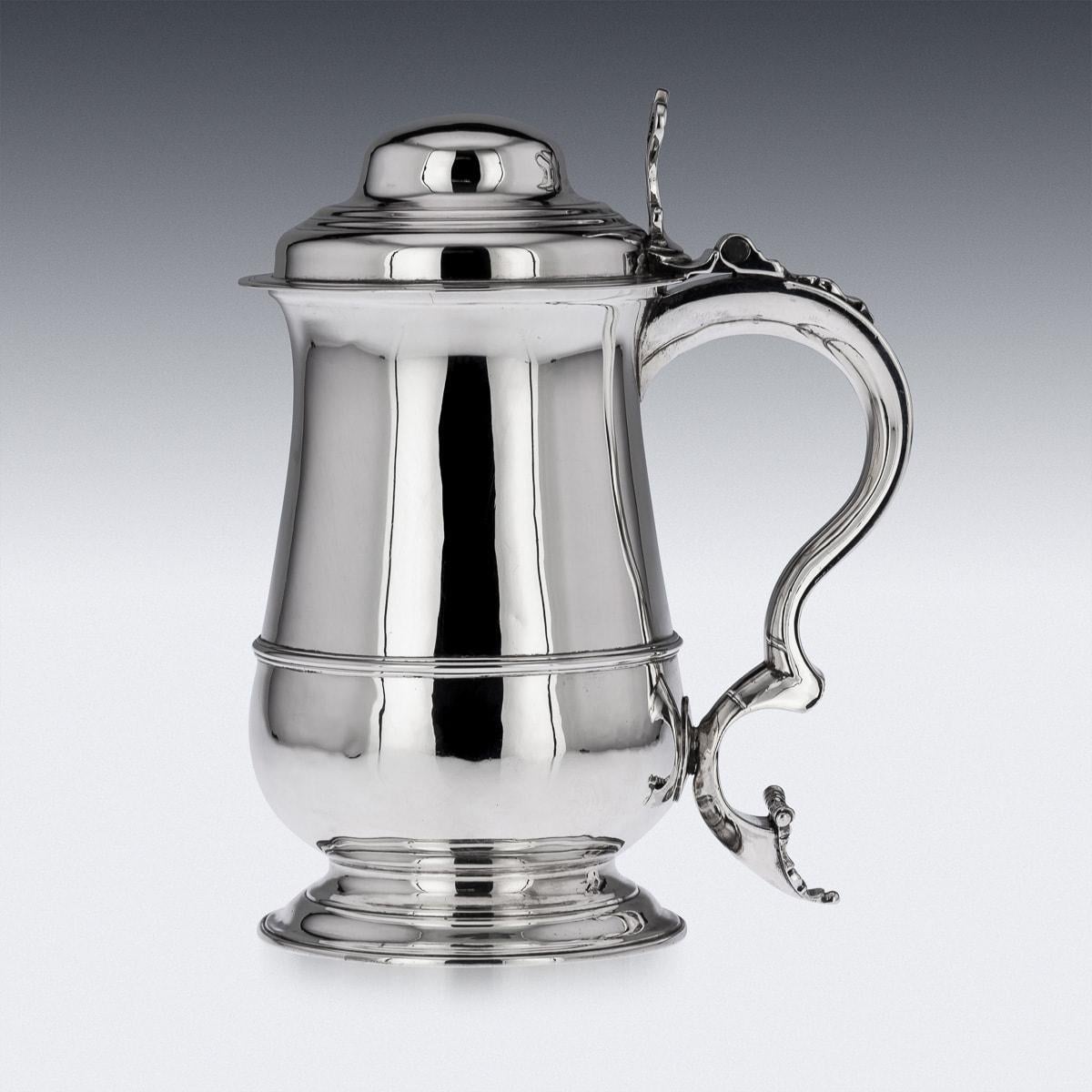 Antique 18th Century Georgian solid silver lidded tankard, the domed lid is applied with a cast thumb-piece, the scrolled handle terminating in a scripture. The tankard features a bellied body on a flared foot, the sides smooth with a reeded band