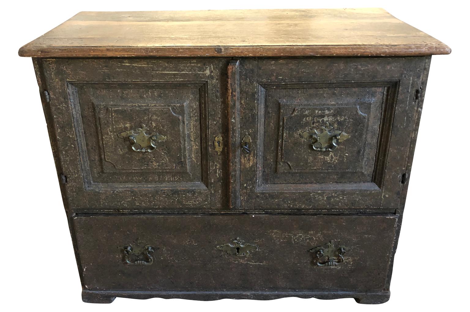 A very handsome mid-18th century Baroque style cabinet from Germany. An interesting construction with double doors over a large drawer in its original painted finish. A terrific storage piece.