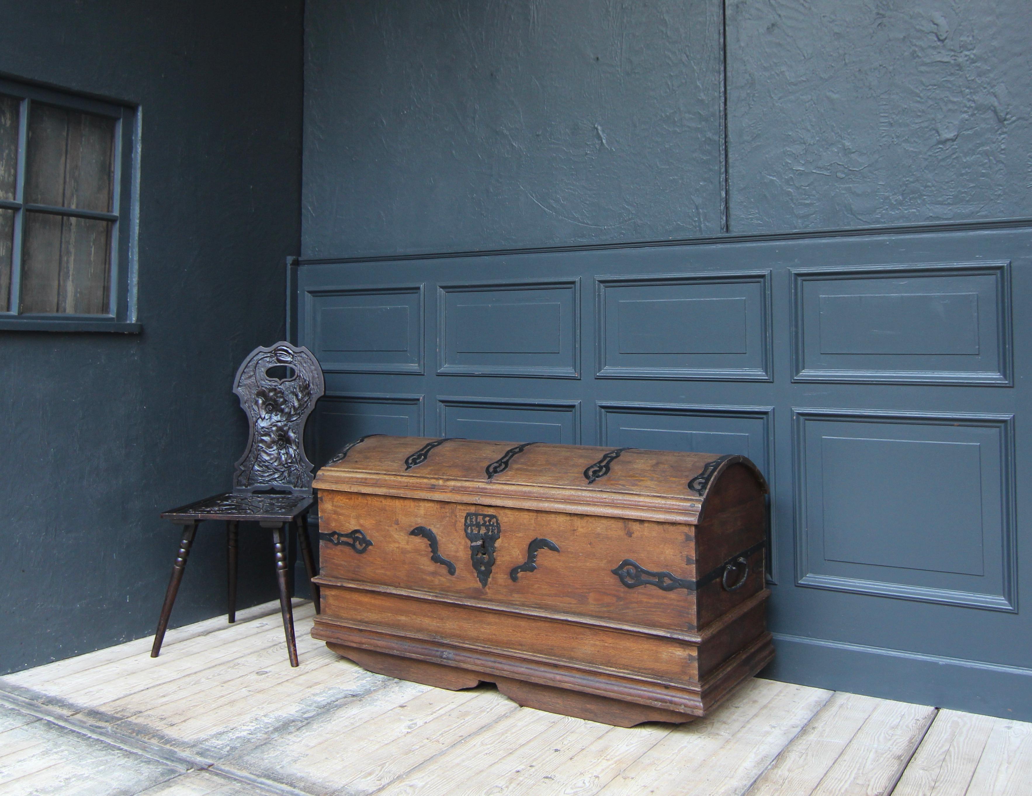 Originale cassapanca barocca tedesca a coperchio rotondo del XVIII secolo. Realizzato in legno massiccio di Oak e riccamente decorato con accessori forgiati a mano. Monogrammi con 