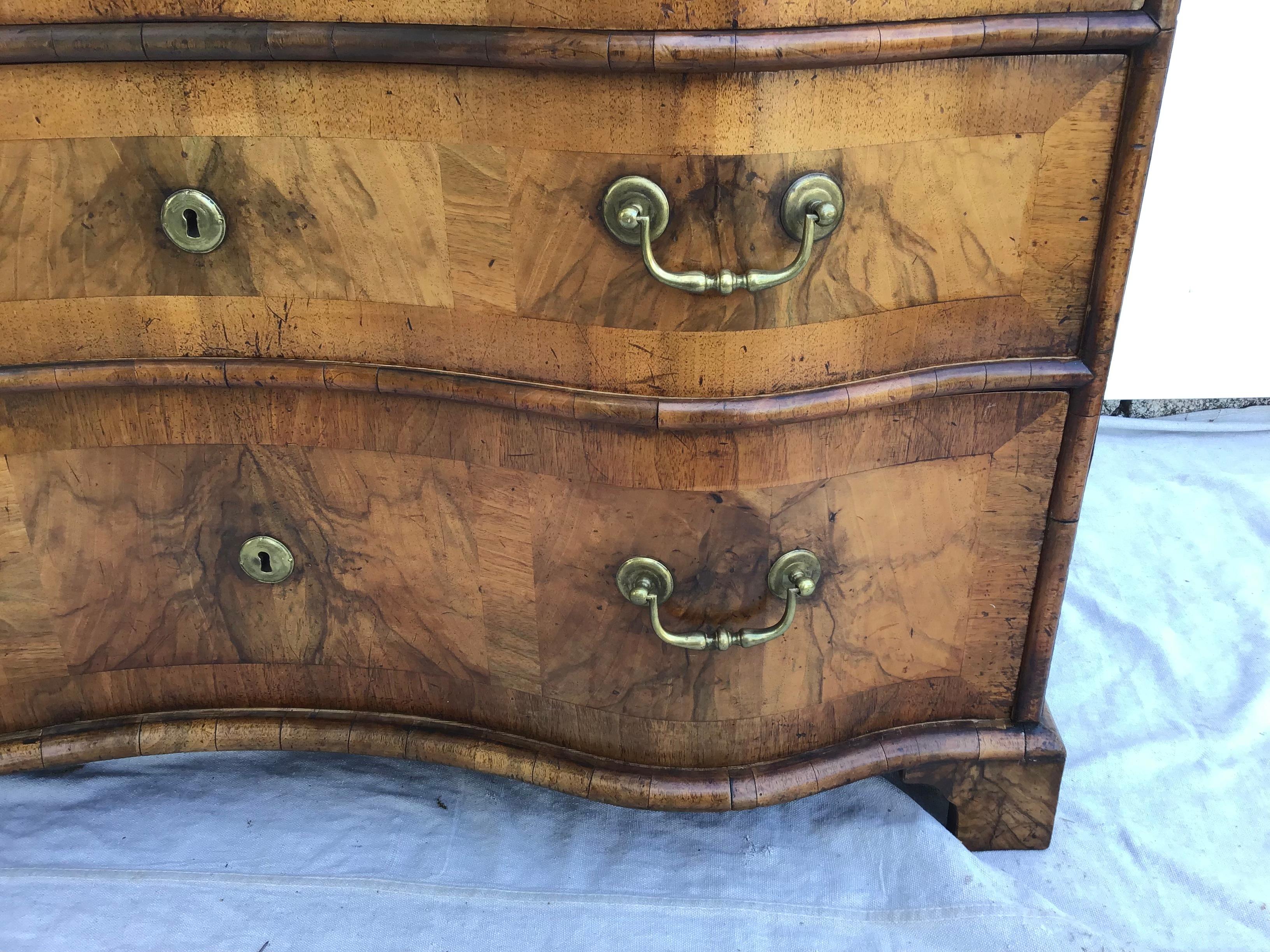 A very fine quality 3-drawer Baroque German commode in walnut with inlaid fruitwood Marquetry decoration, the serpentine drawers retaining their original locks and brass drawer pulls and escutcheons, mid-18th century.