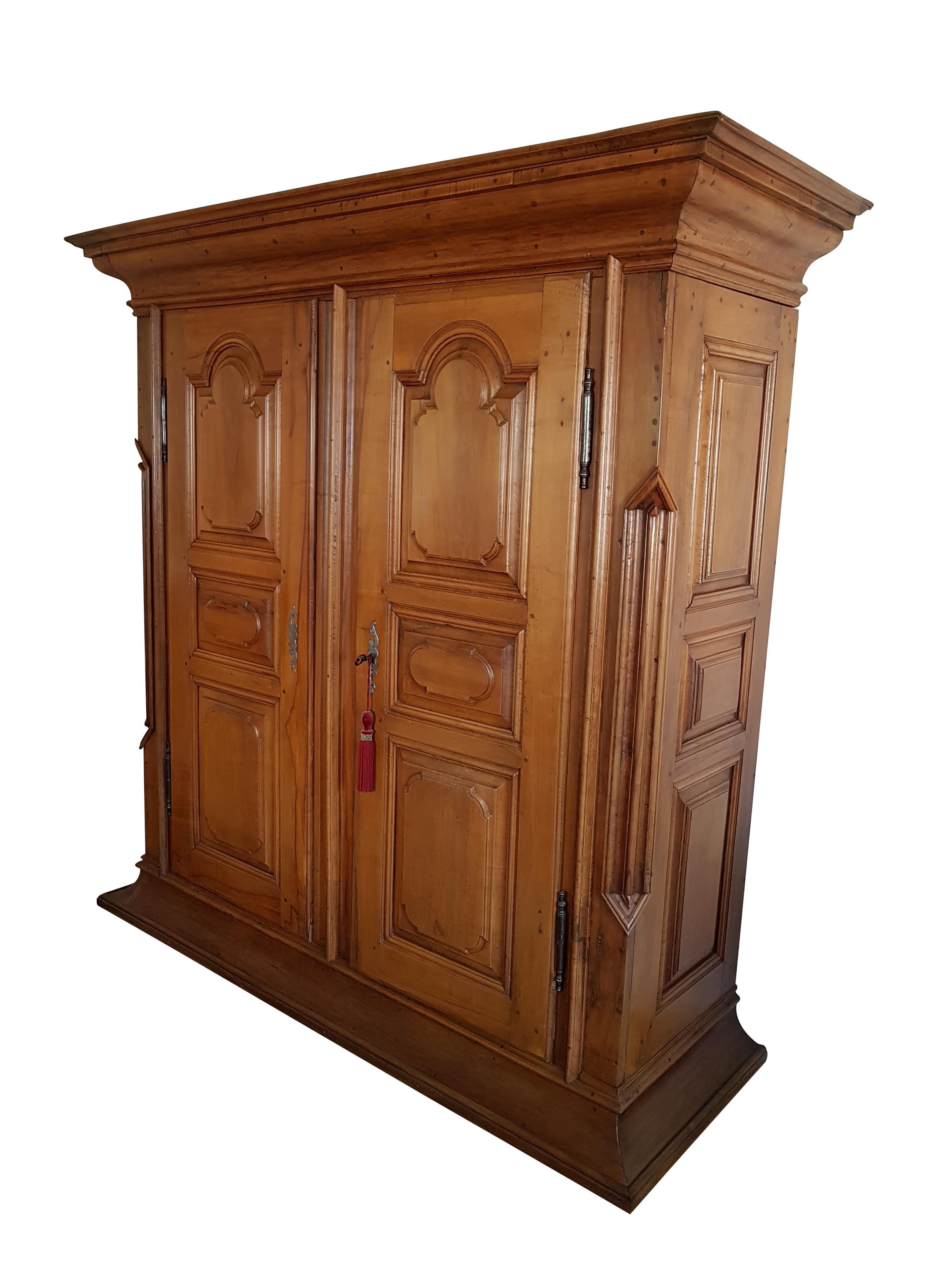 Dieser bemerkenswerte barocke Saalschrank aus dem 18. Jahrhundert stammt aus der Westpfalz und ist meisterhaft aus massivem Birnbaum gefertigt - einem hoch geschätzten Material für die Herstellung feiner Möbel.

Der Schrank hat einen klassischen