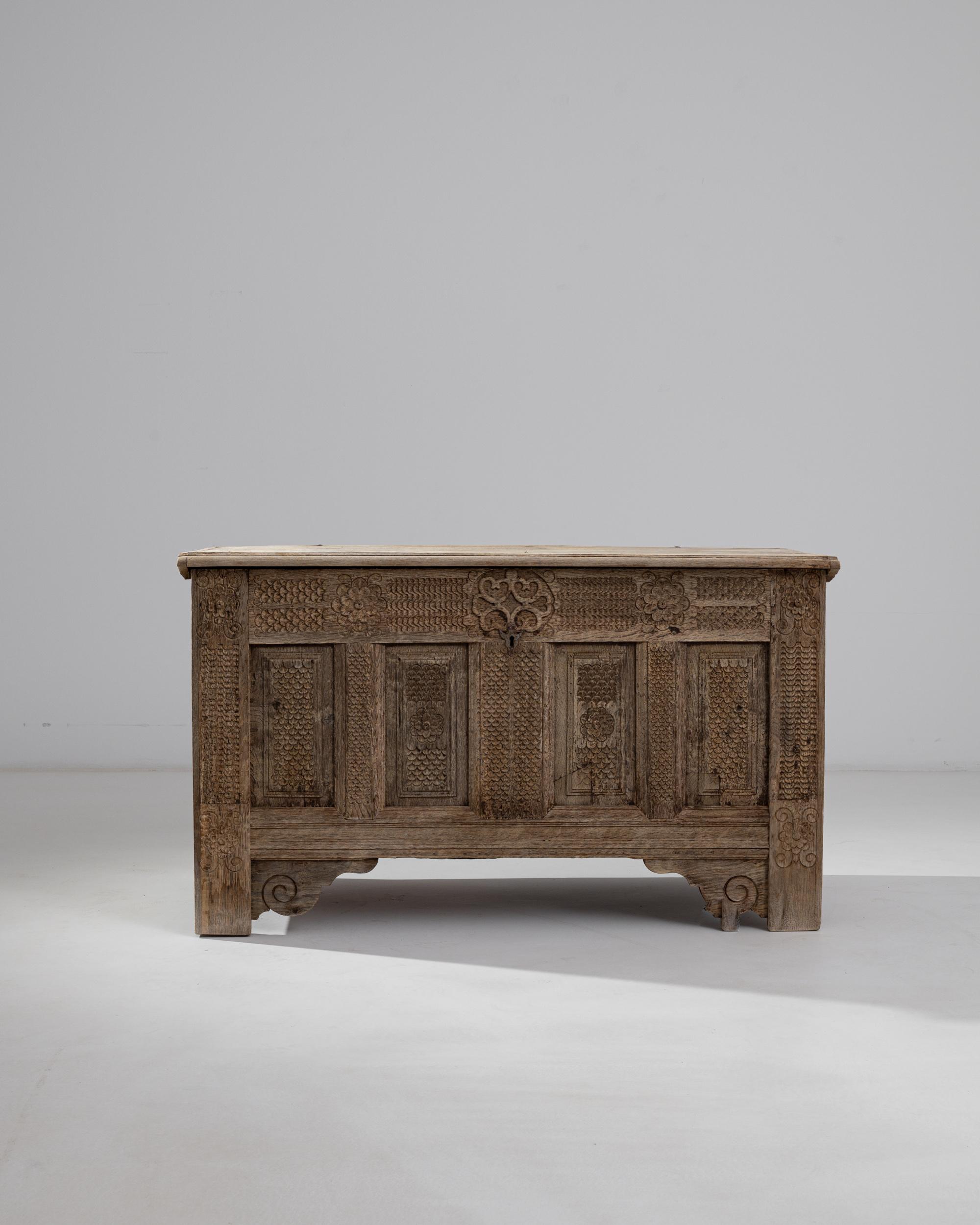 Detailed carving gives this antique gothic trunk a rich optical quality. Made in Germany in the 18th century, the form of the oak chest is simple, set upon sturdy plank-like legs. The solid slab of the lid opens upon original iron hinges, while