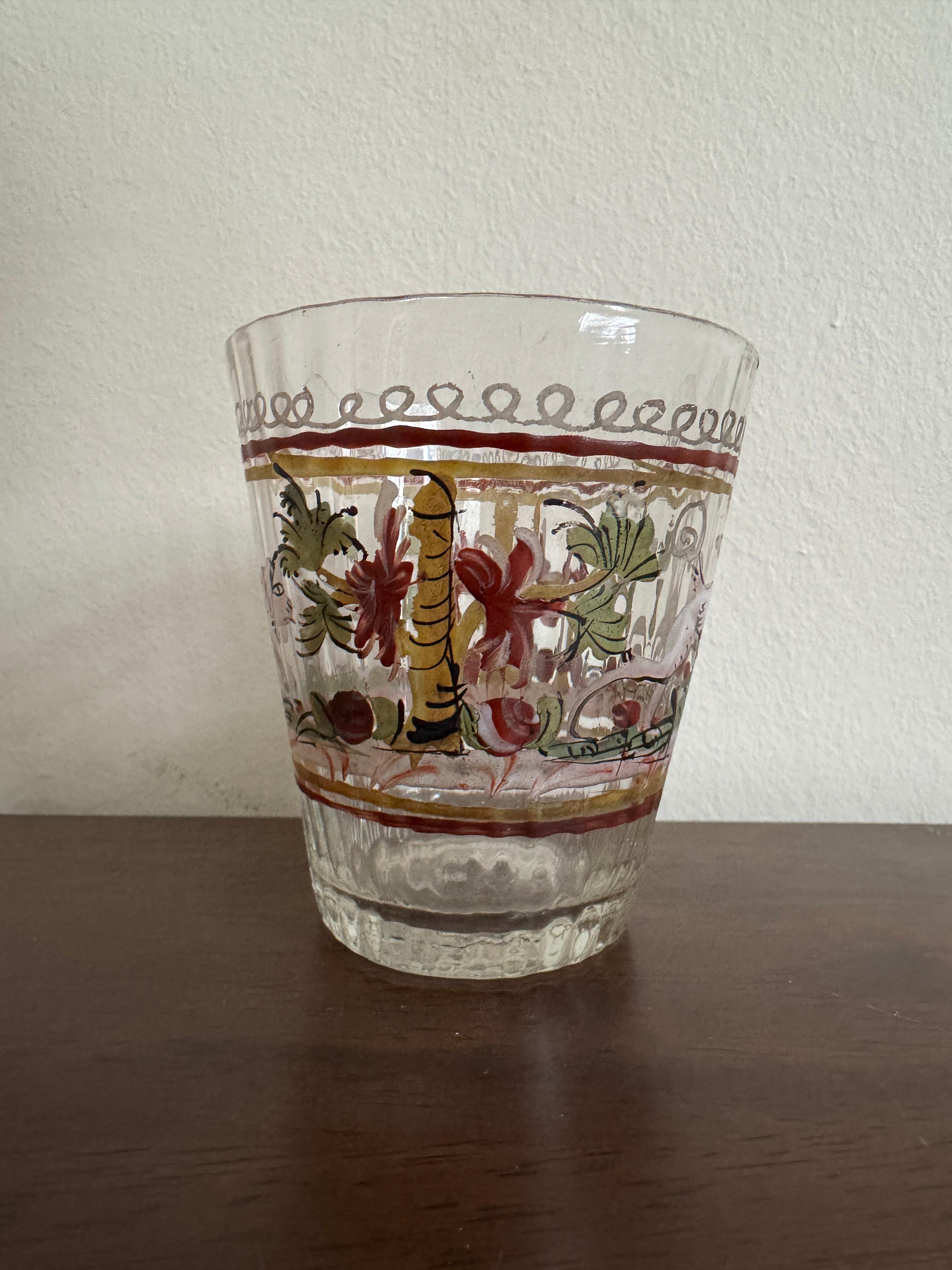 Ein deutscher oder möglicherweise böhmischer Klarglasbecher aus dem 18. Jahrhundert, handdekoriert mit Bäumen und Blumen sowie einem Hund und einem Hirsch, was auf ein mögliches Jagdthema hindeutet.

9cm / 3.5