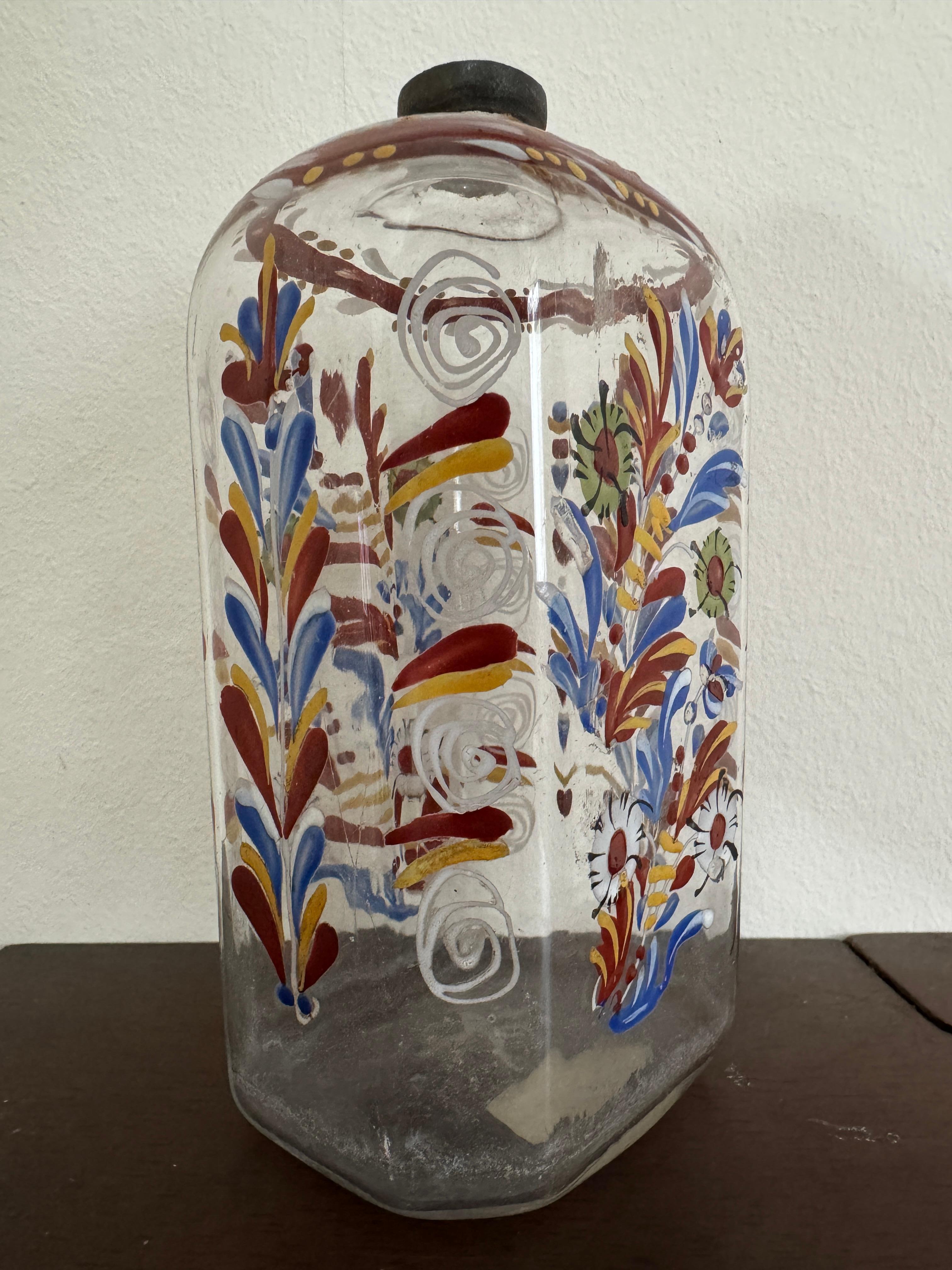 Bottiglia di vetro trasparente del XVIII secolo, tedesca o forse boema. Forma ottagonale appiattita. Decorata a mano con fiori blu, arancioni e verdi.

15,5 cm di altezza