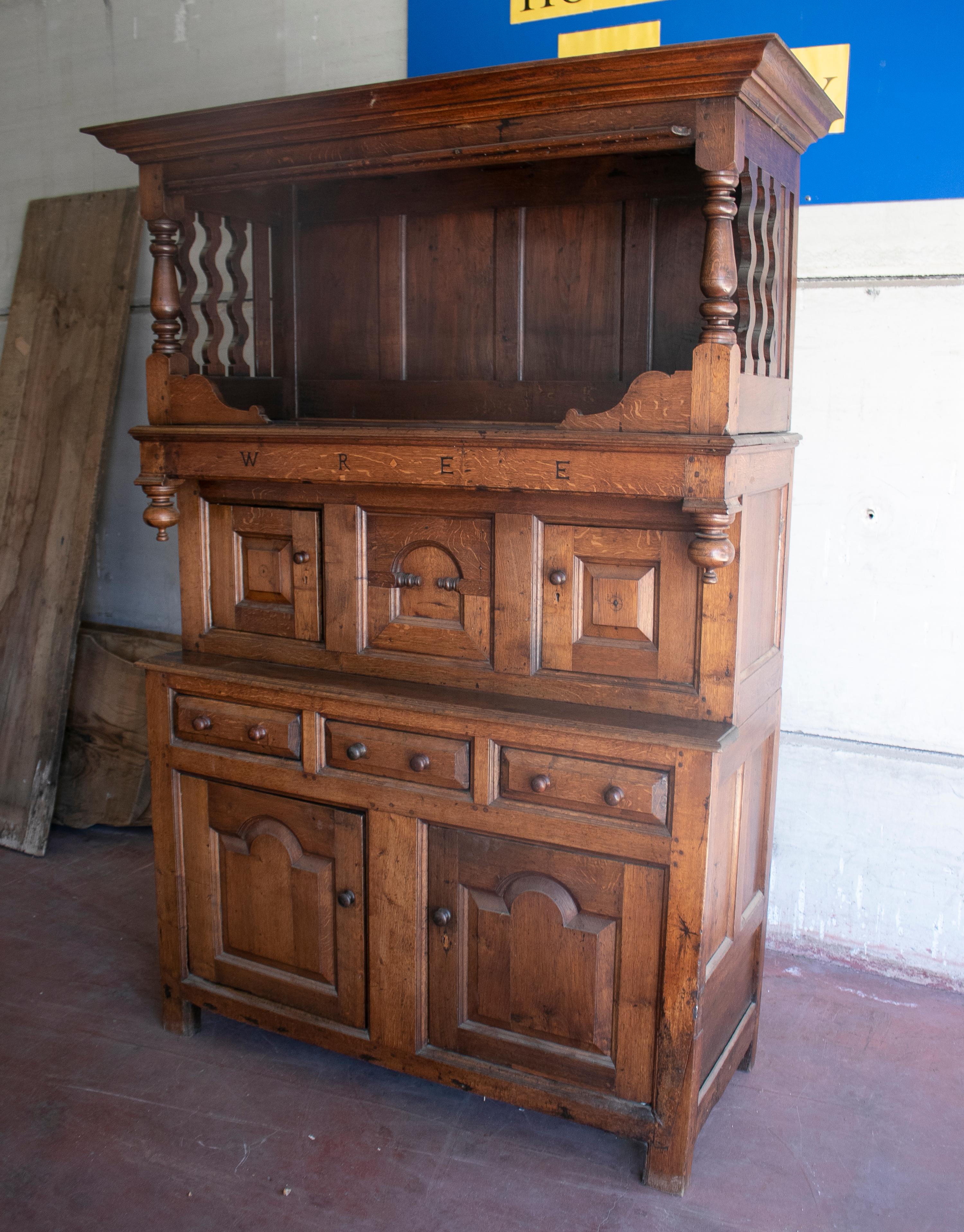 18th century German court cupboard with drawer, paneled doors and carved letters spelling WREE.
  