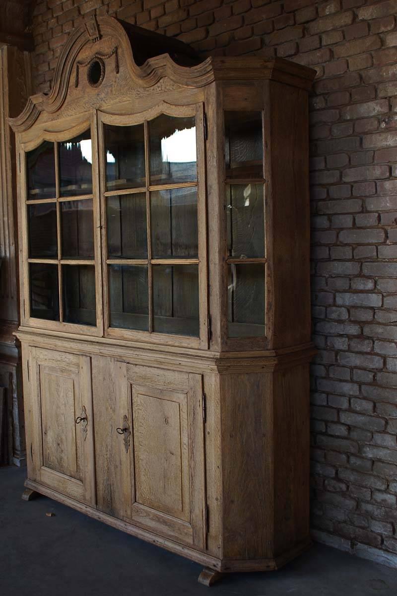 This German baroque display or kitchen cabinet has its original glass and hardware.
The upper cabinet has canted corners, a stepped pediment above two arched glass inset doors.
Note the small proportions of the wood on the upper cabinet,