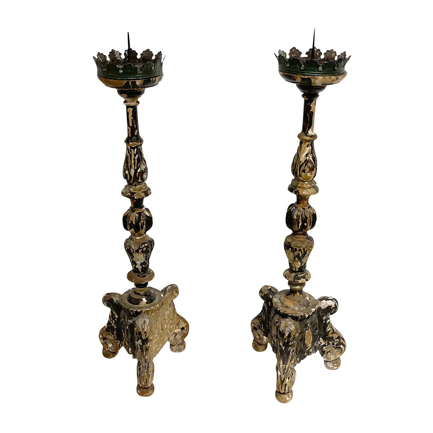 An antique German pair of altar candlesticks made of hand carved Wood, in good condition. The tall candle holders is composed with a slim, articulated shaft, metal drip catcher with ridged edges and a metal mandrel, supported by a three-pass base on