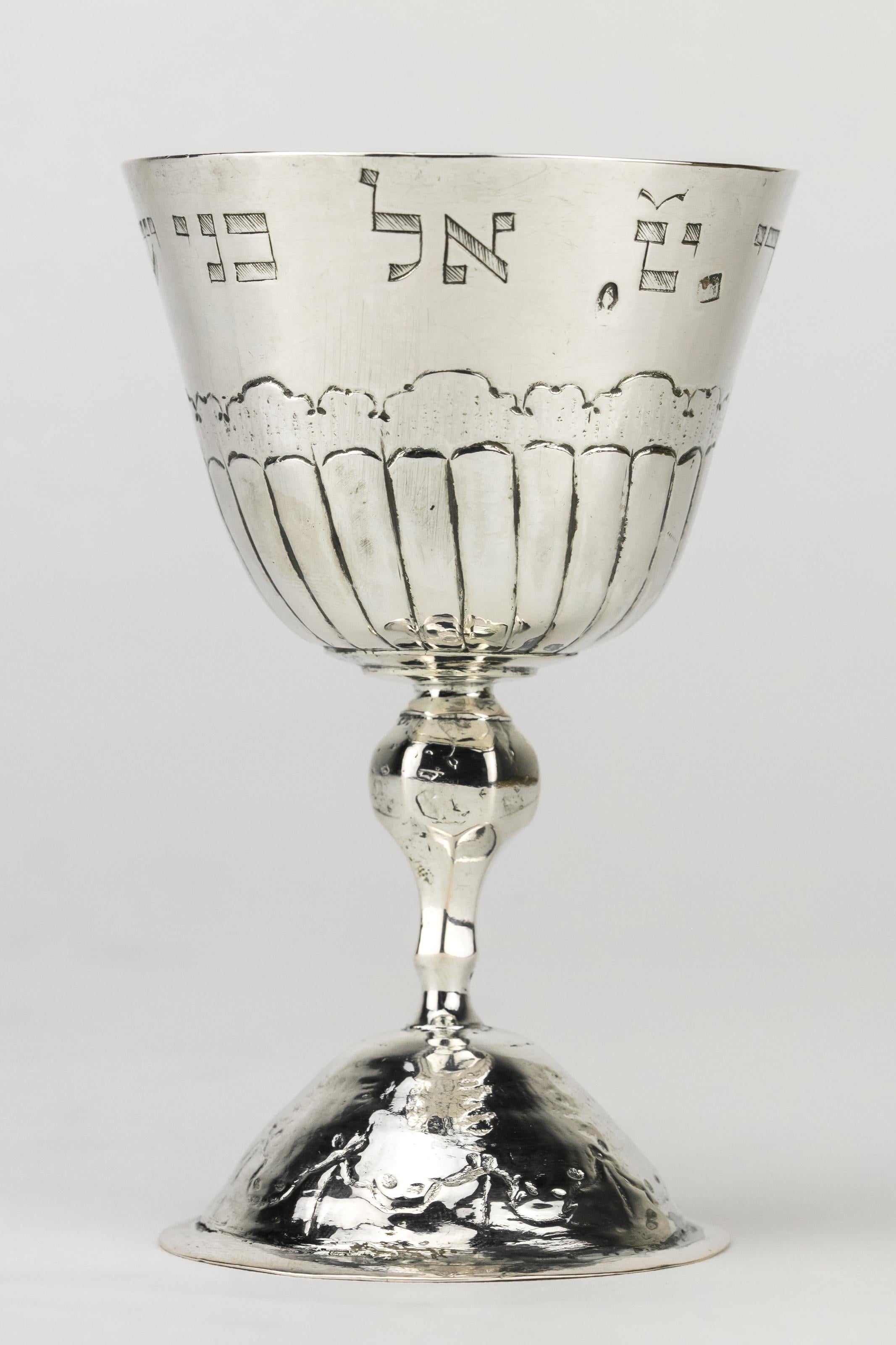 Silver Kiddush Goblet, Hieronymus Mittnacht, Augsburg, Germany, 1763-1765.
Classic style tulip-form bowl with chased scalloped design motif with faceted baluster stem set on circular base with coordinating chasing, Along the edge of the bowl the