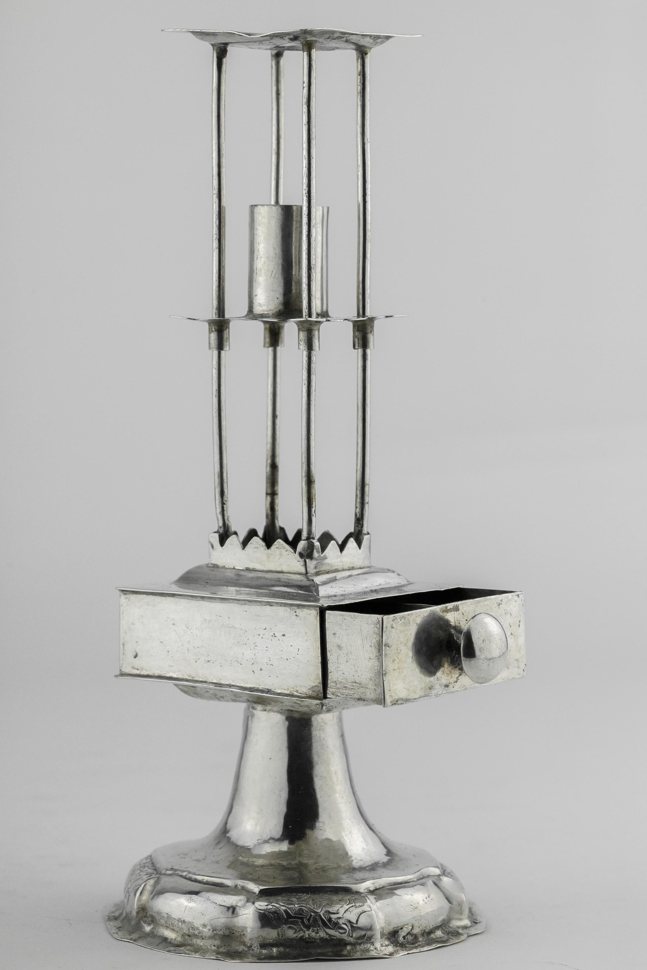 Silver Havdalah candlestick with Spice Drawer, Nuremberg, Germany, circa 1720.
On a fluted domed foot chased with foliage and scrolls at intervals, surmounted by a four-compartment spice drawer with domed side handle and raised scalloped top, the