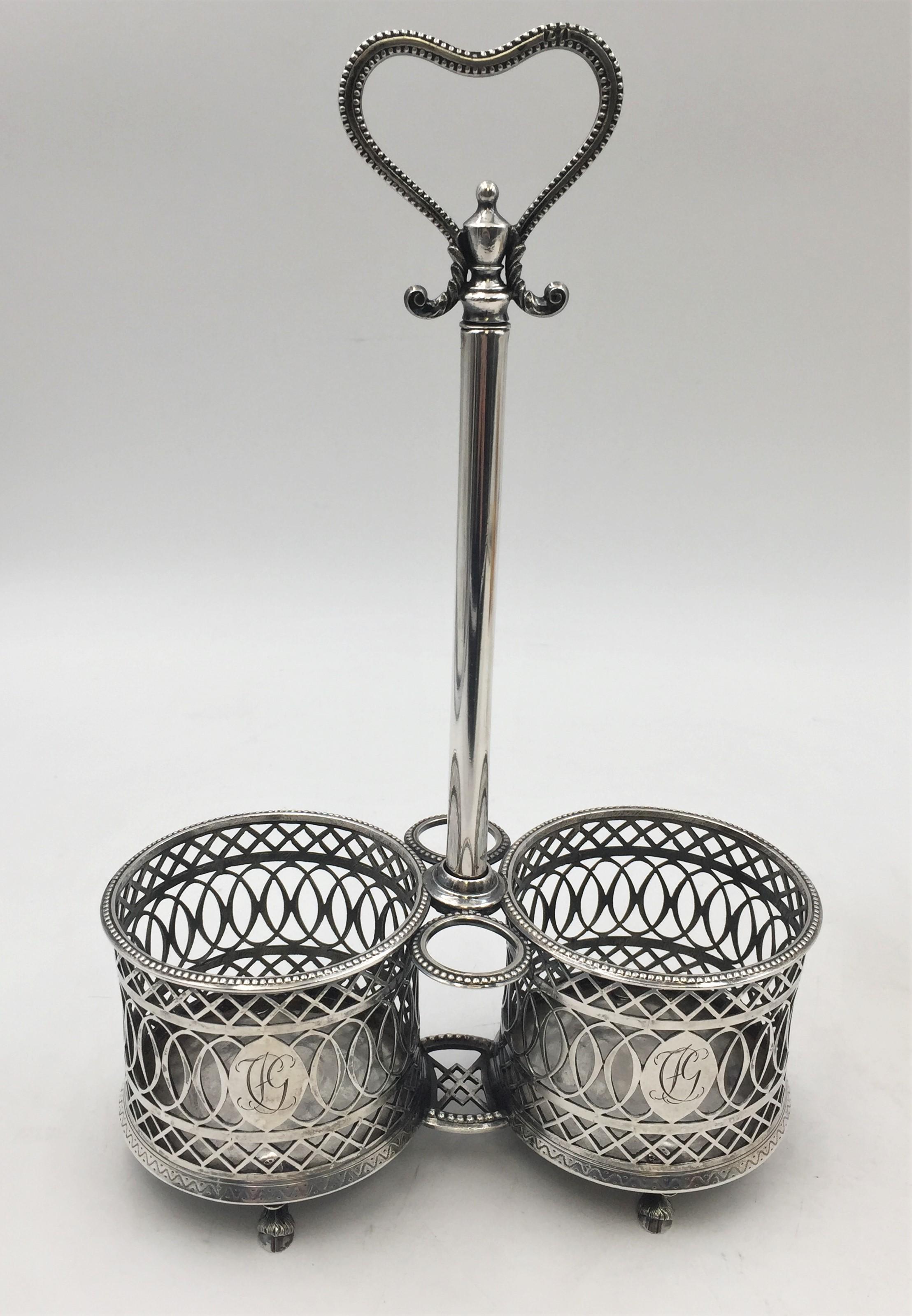 Continental silver cruet, most likely German and from the 18th century, with exquisite pierced work and cartouches with engraved monograms, standing on 4 animal-shaped feet, with 2 glass bottles with stoppers. The holder measures 11 1/2'' in height