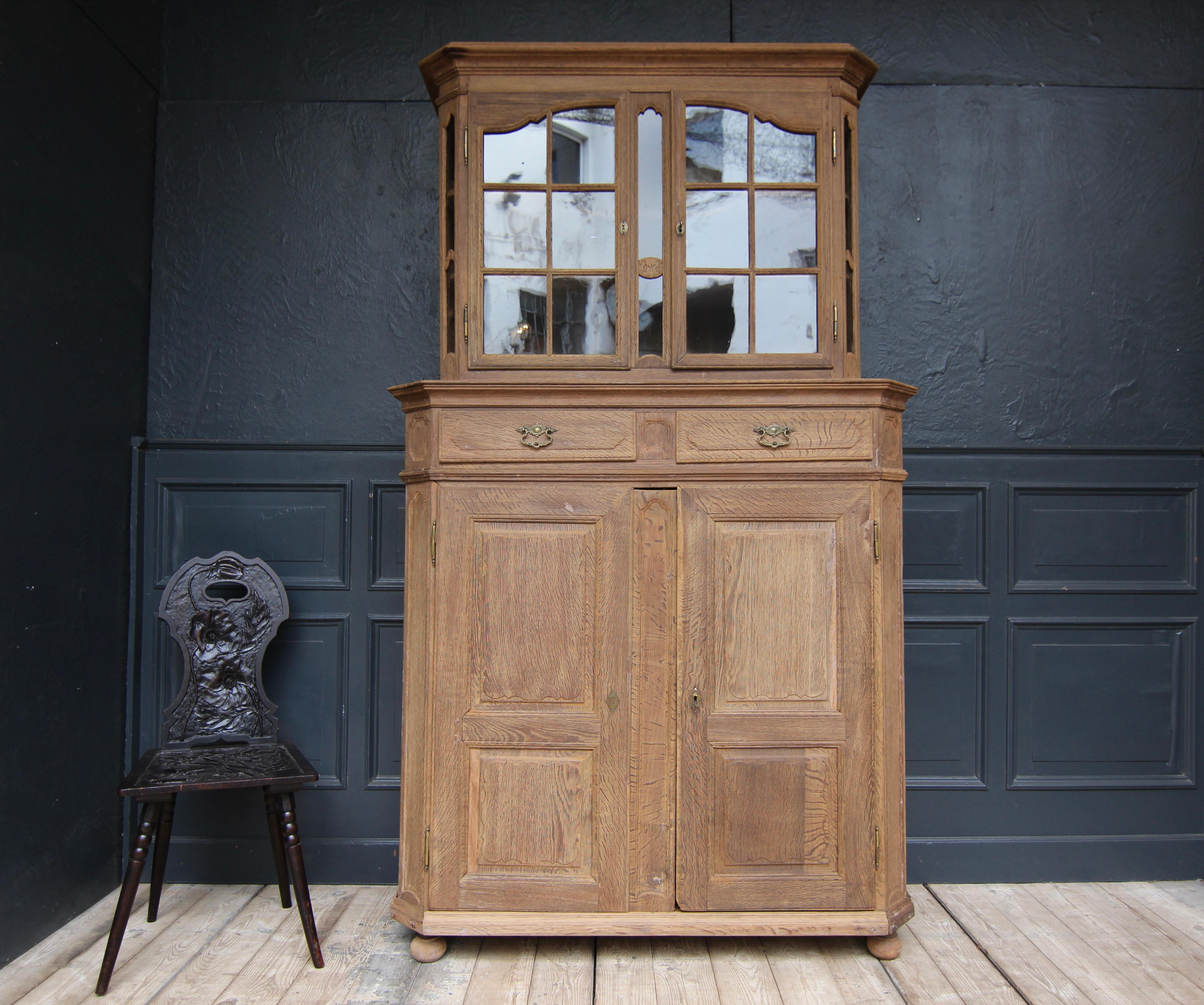 German provincial Baroque display cabinet or buffet. West German, 2nd half of the 18th century. Solidly made of oak and partially carved.

The wood has been stripped of the old wax, revealing the beautiful surface of the raw oak wood and allowing