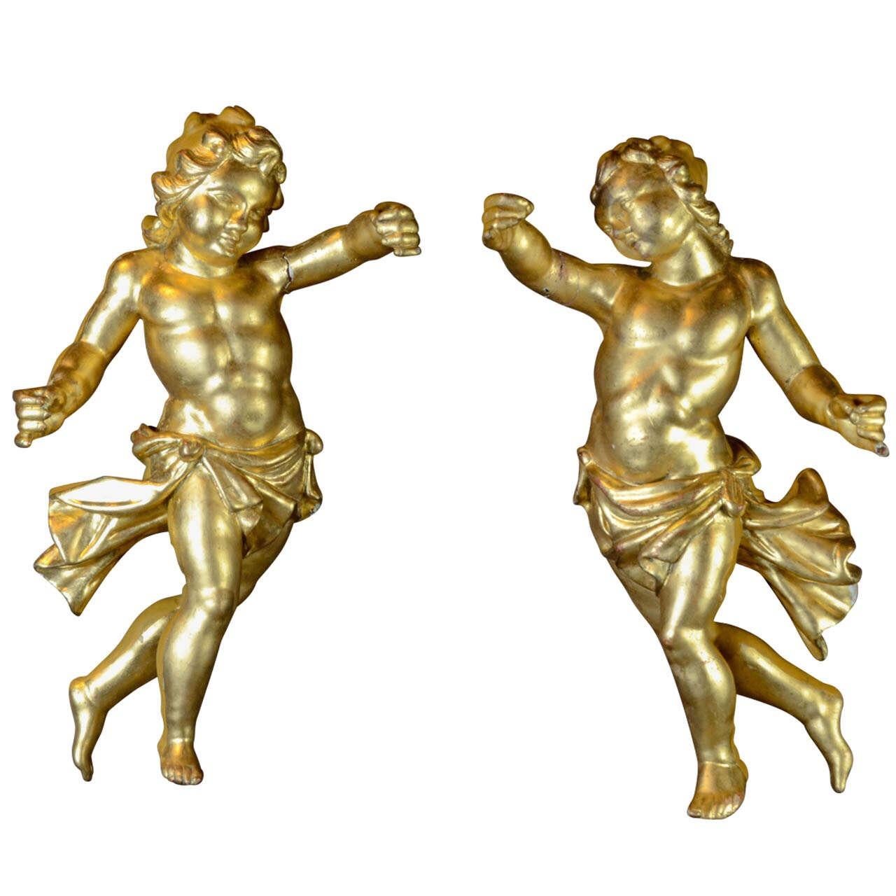 A rare and magnificent pair of ancient 18th century Italian sculptures depicting Baroque Putti. 
The style, quality and workmanship of this pair of winged angels in gilded wood with gold leaf, suggest a noble production in central Italy, most likely