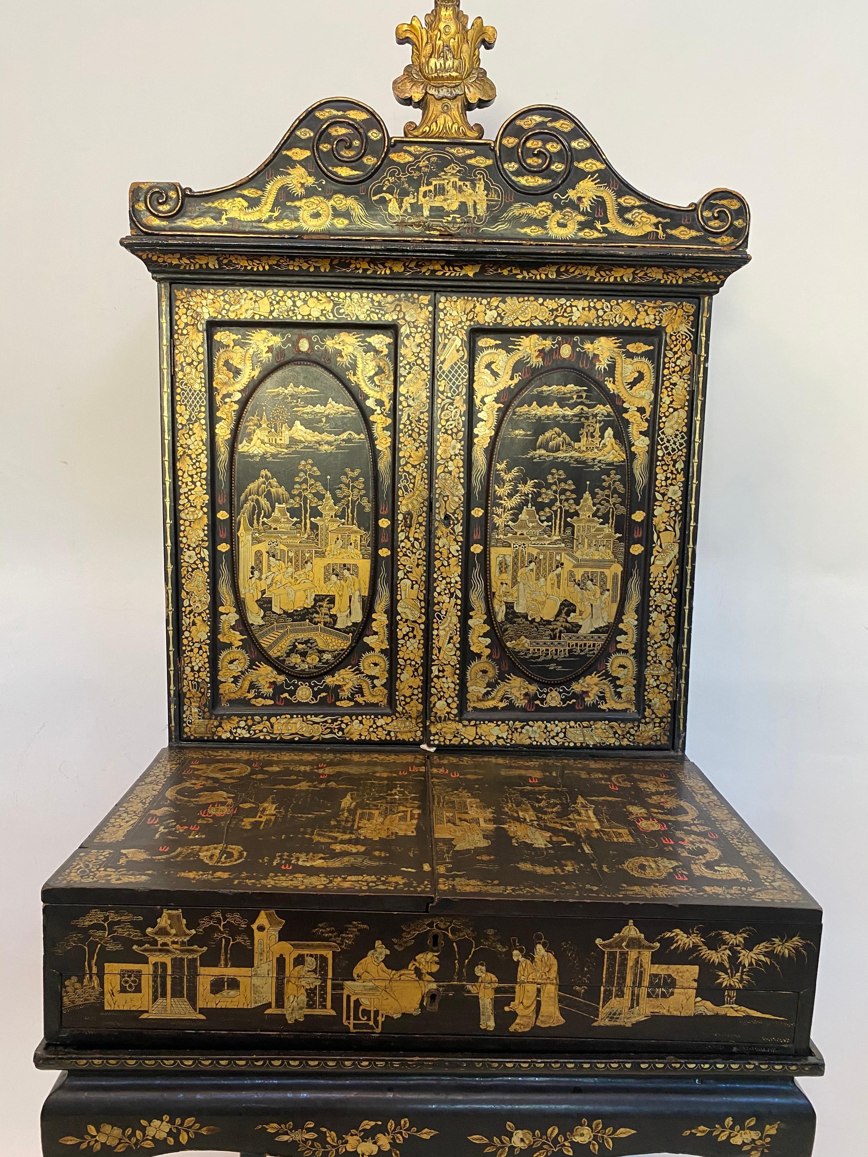 A 18th century Chinese export lacquered George III style black and gilt ladies dressing chest, in the form of a chinoiserie secretaire, the top with swan neck pediment above twin cupboard doors, each decorated with vignettes of courtly figures in