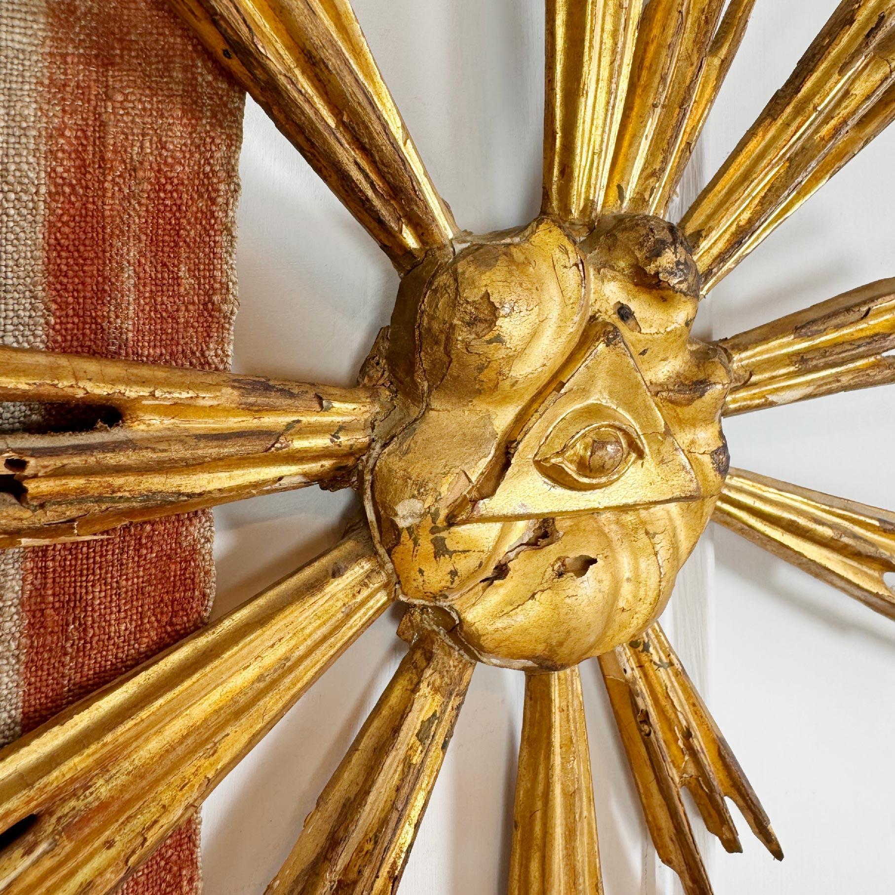 An incredible and very rare late 18th century Italian giltwood sunburst, with the All Seeing Eye of God to the centre surrounded by a formation of clouds, in beautiful time worn condition, one ray has been lost over time.



Height 52 cm x Width 44