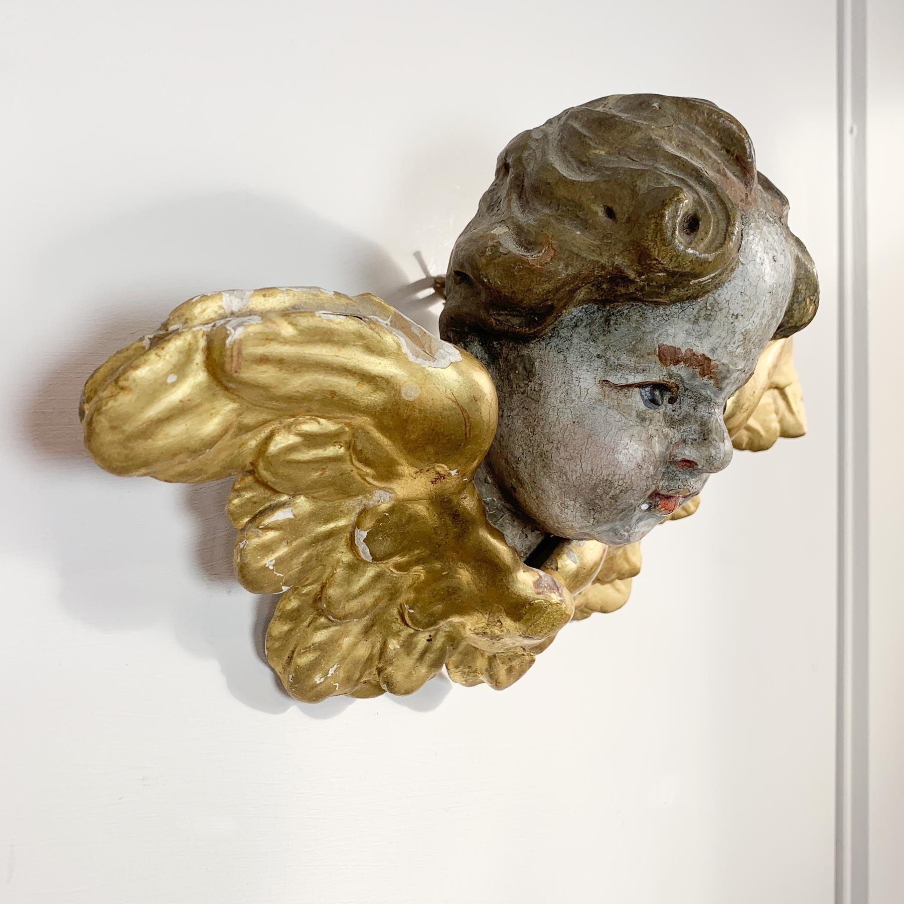 Hand carved winged German Baroque Putti, water gilded over applied gesso, the face and head polychrome painted. Small hanging loop to the back of the head.

Width 26cm x Height 19cm x Depth from hanging loop 11cm.

