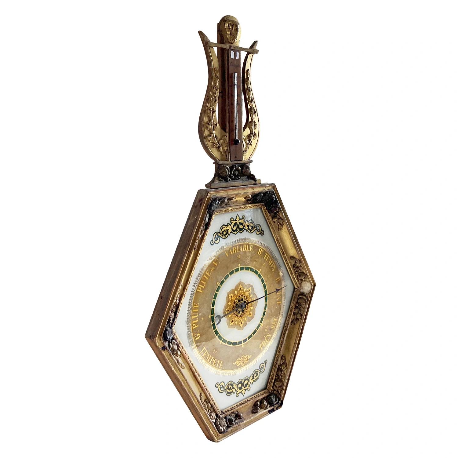 A rare antique finely worked French barometer with lyre shaped crest thermometer above a large hexagonal framed barometer. The Parisian décor piece is made of hand carved gilded wood in good condition. The barometers from this period were often used