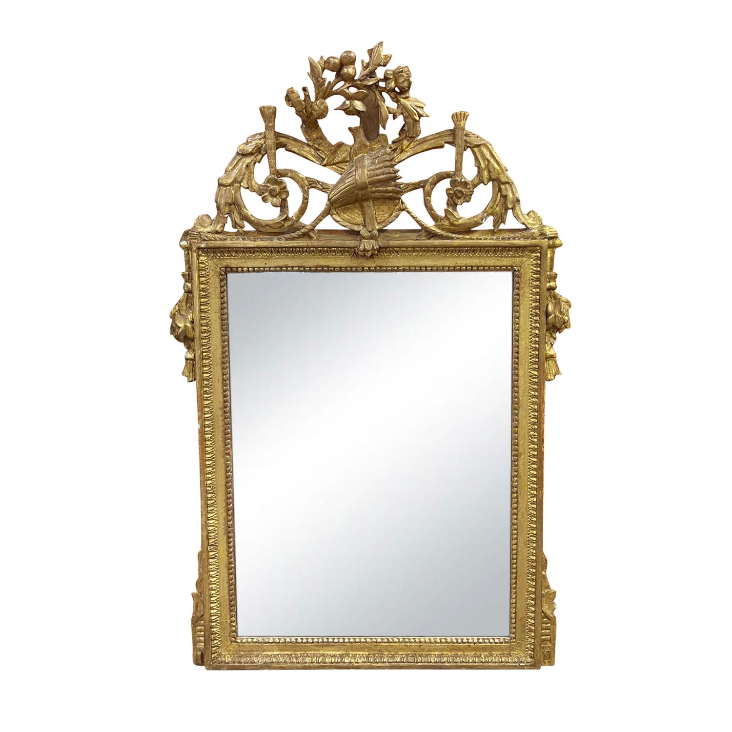Late 18th Century, an antique Louis Seize period mirror in carved wood with gilded accents and foliage motifs, consisting its original mirror glass in good condition. Created in France during the reign of Louis XVI. The frame features an exquisite