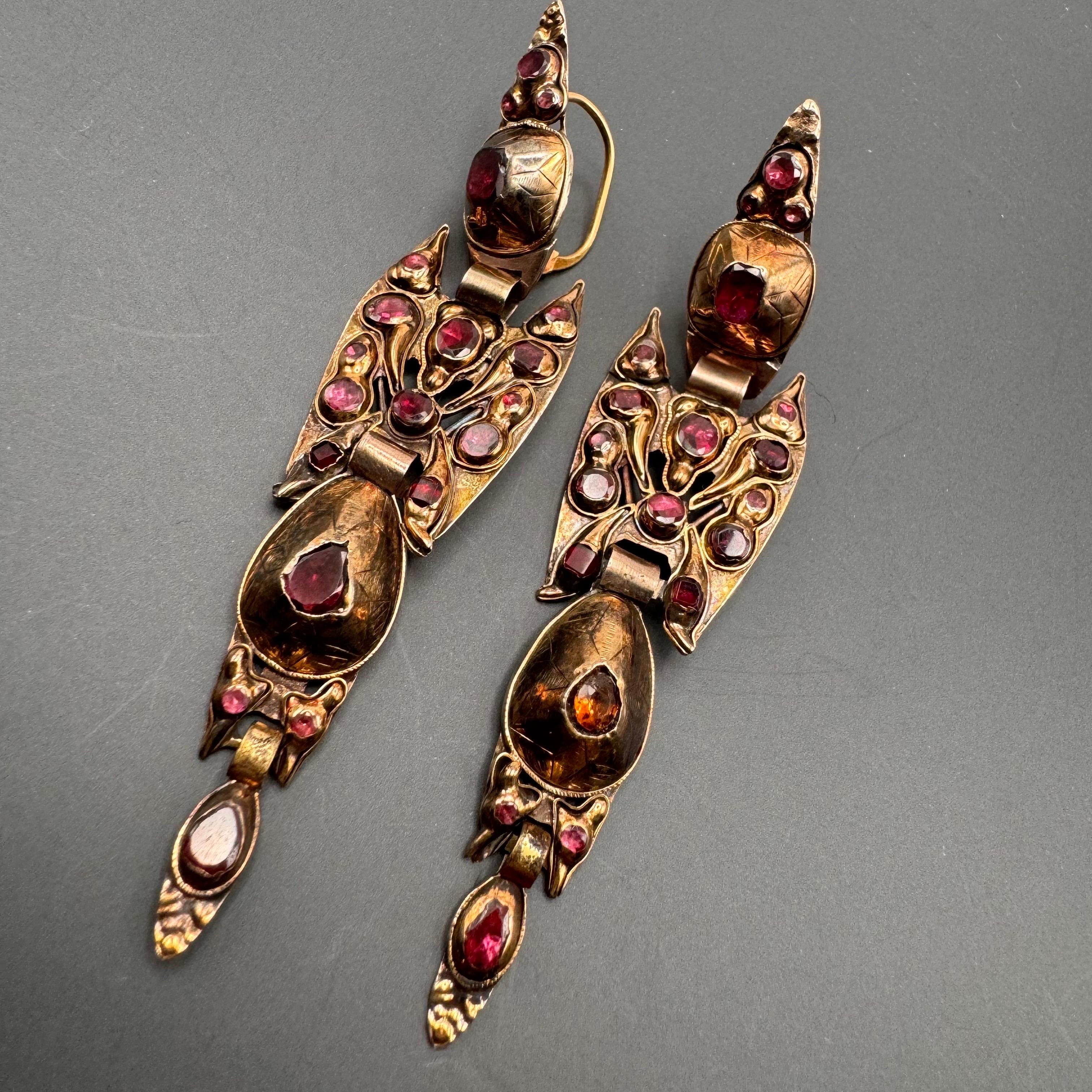 This stunning pair of pendeloque-style earrings hails from Iberian Spain, dating back to the late 18th century. Crafted from 14k gold, these earrings feature a classic teardrop design, offering a timeless elegance and opulence.

Each earring is