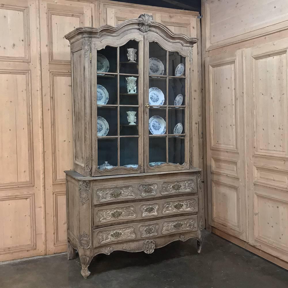 18th century Grand China buffet or bookcase with commode features beautiful and graceful lines, from the triple arched crown centered with a shell carving to the hand-rolled glass display tier above, to the elaborately hand-sculpted three-drawer