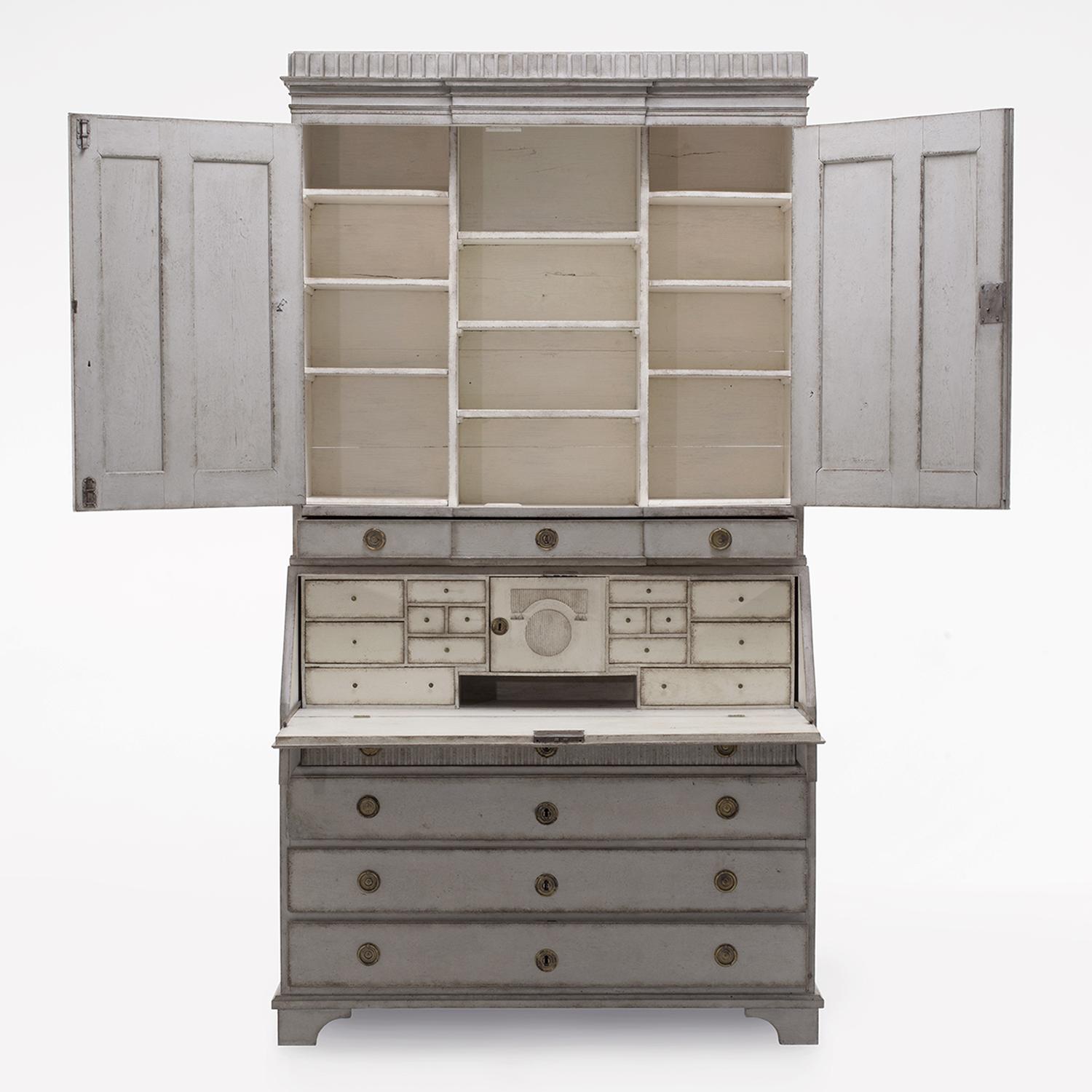 A 18th Century, light-grey, white antique Swedish Gustavian two part bureau made of hand crafted painted Pinewood, in good condition. The Scandinavian secretaire is composed with two upper doors and a writing flap, four large drawers and many small