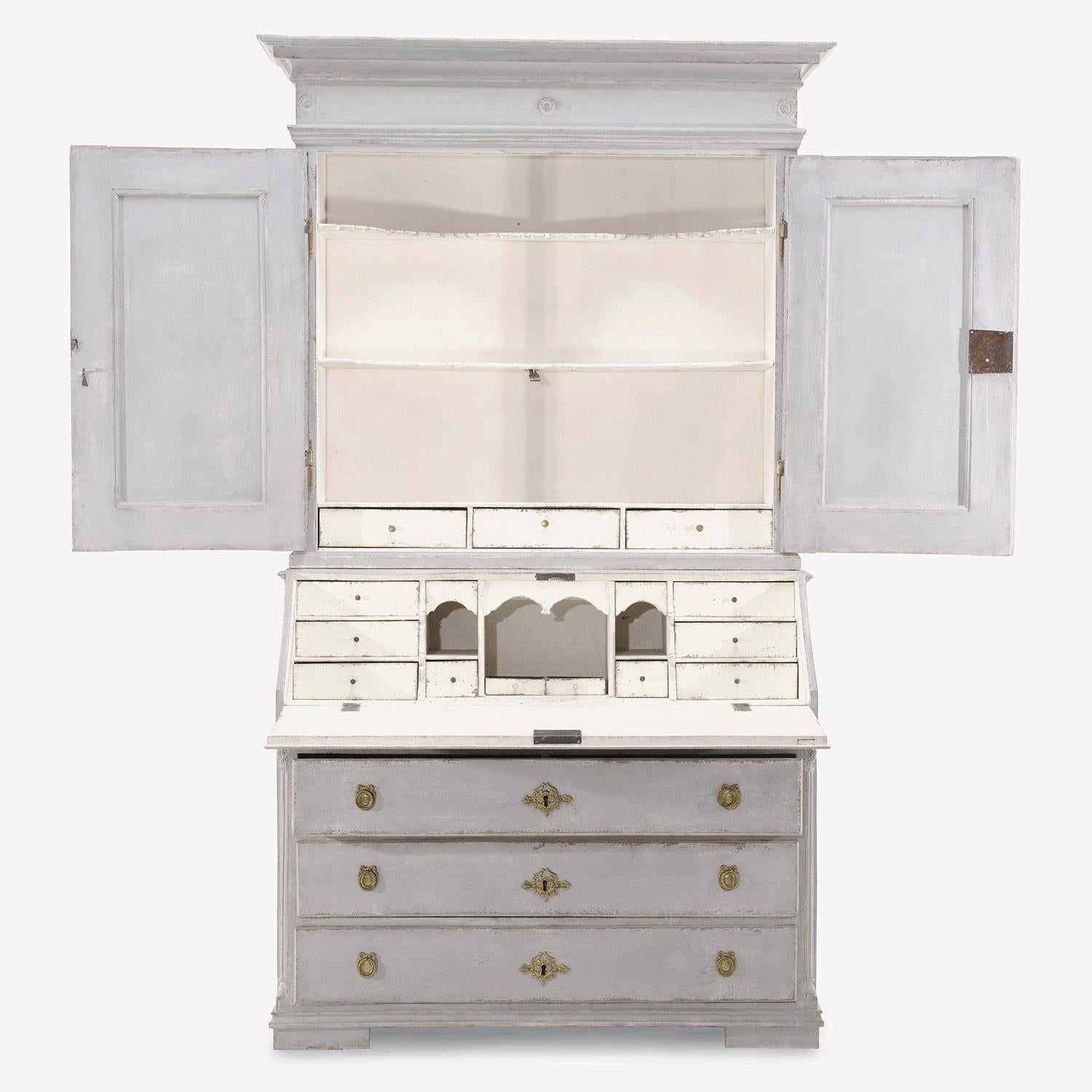 A light-grey, white antique Sweden Gustavian two part bureau with a writing flap made of hand crafted painted Pinewood, in good condition. The Scandinavian writing table, desk is composed with two upper doors, three large drawers and many small