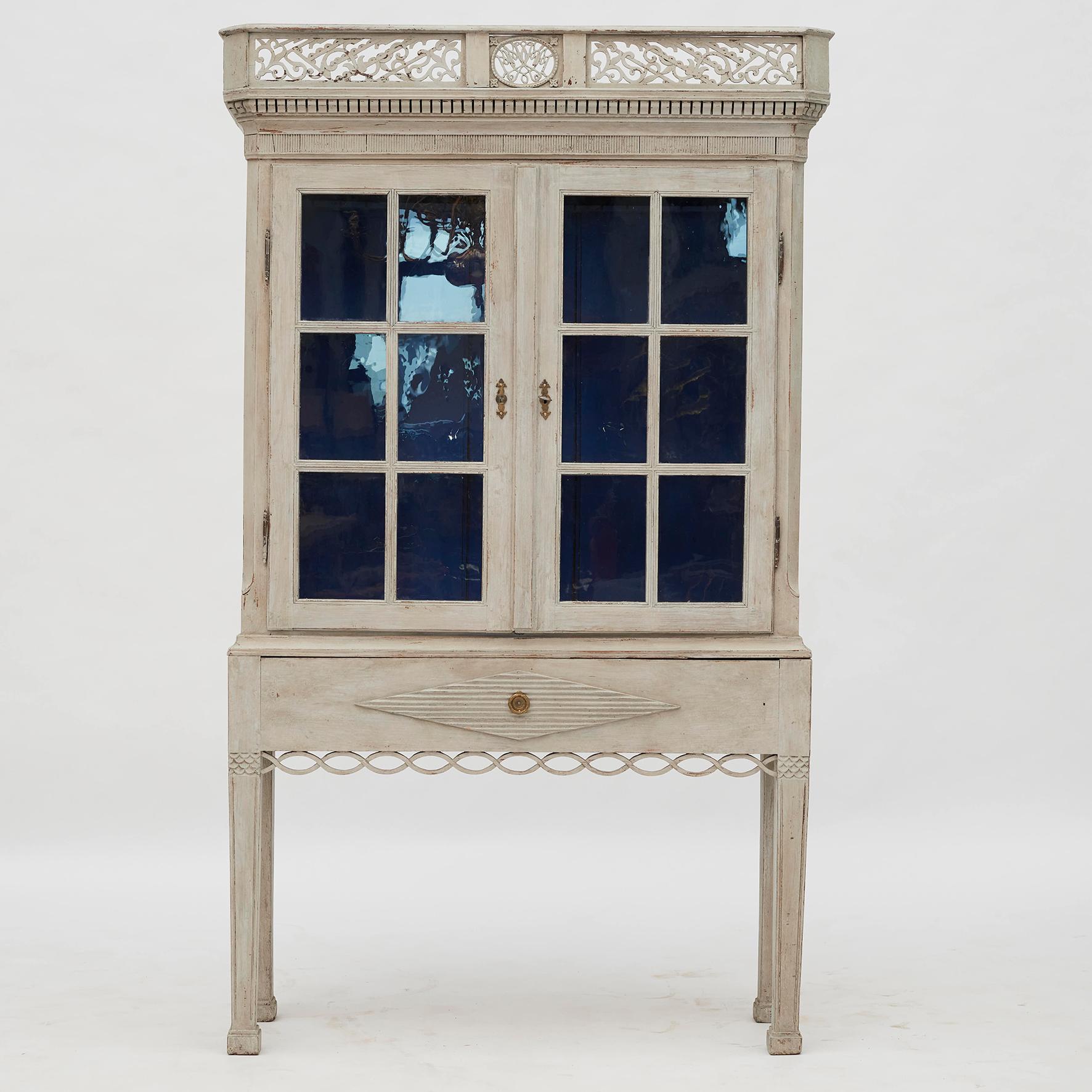 A Beautiful Danish Louis XVI (Gustavian) cabinet with paned glass doors. Light gray color with beautiful blue color inside. Original base with fake drawer front. Denmark, 1780-1790.
It will serve dutifully as a display case or storage cabinet.