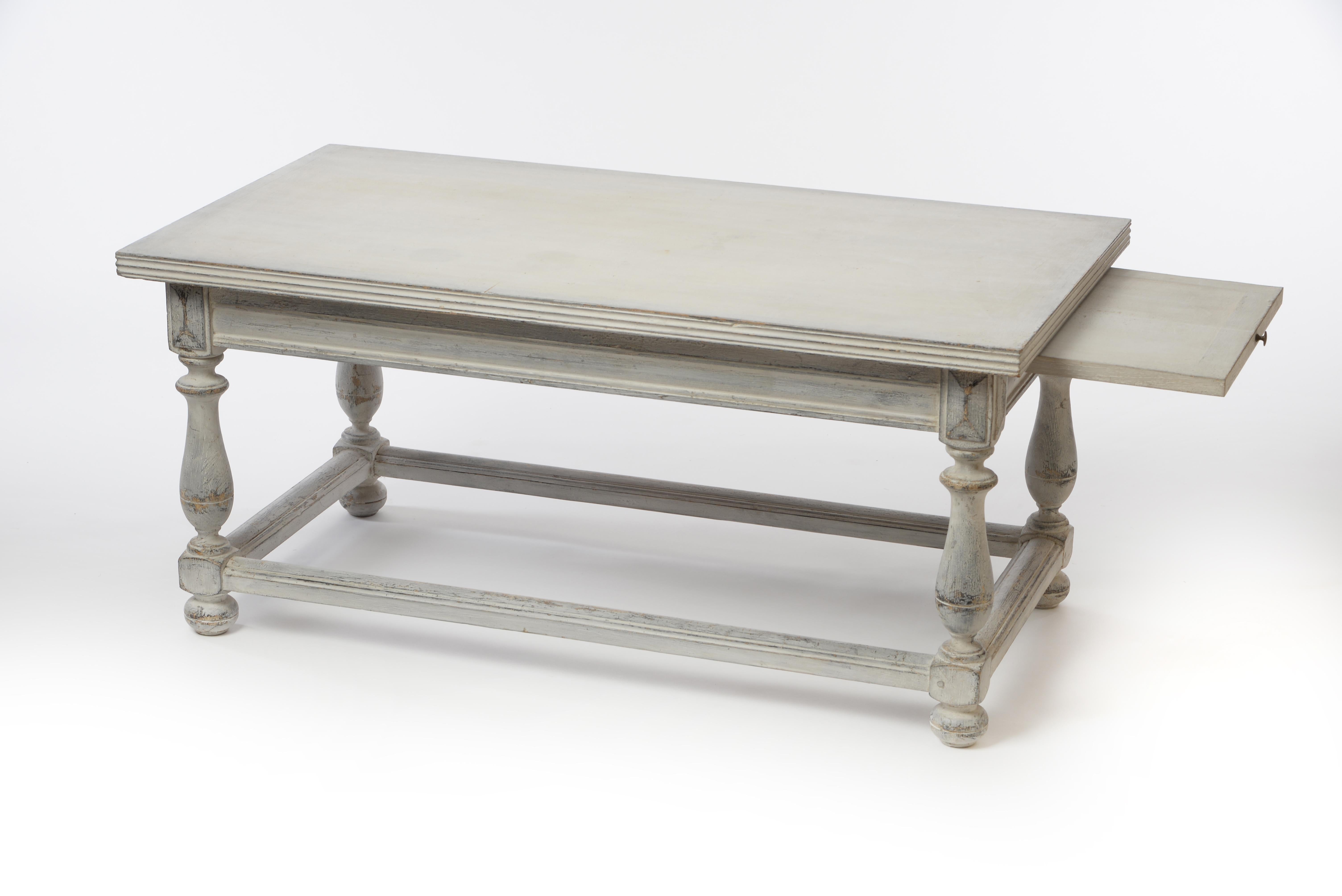 This exceptional Gustavian coffee table from the 18th century features not only interesting legs with an all-around footrest but also practical pullout extensions on each side perfect for placing an extra drink. The table is in good condition and