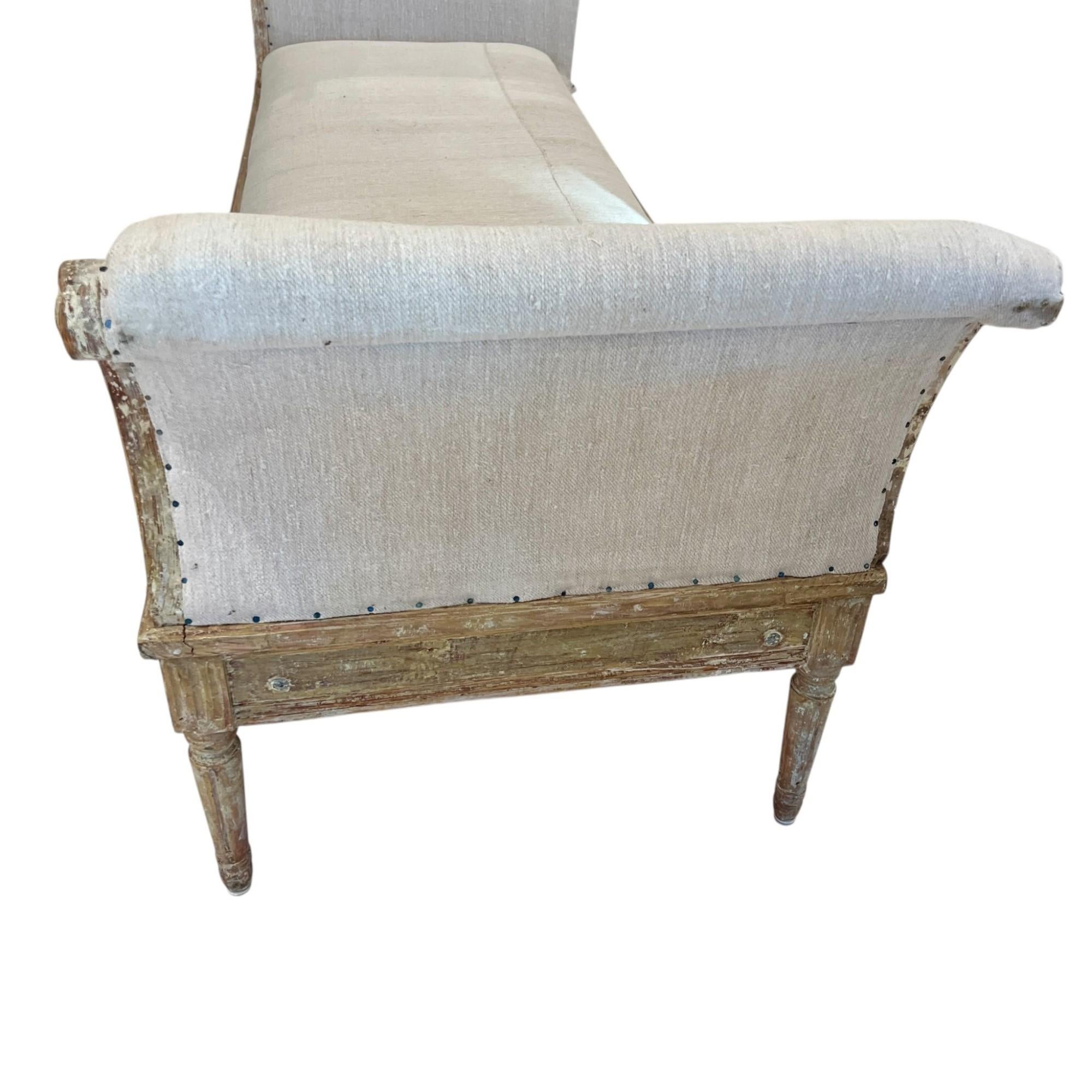 Ce lit de jour gustavien est un exemple intemporel du design néoclassique suédois, inspiré par l'esthétique raffinée de la France du XVIIIe siècle, mais adapté avec une élégance plus légère et plus discrète. Fabriqué en bois sculpté, il présente des