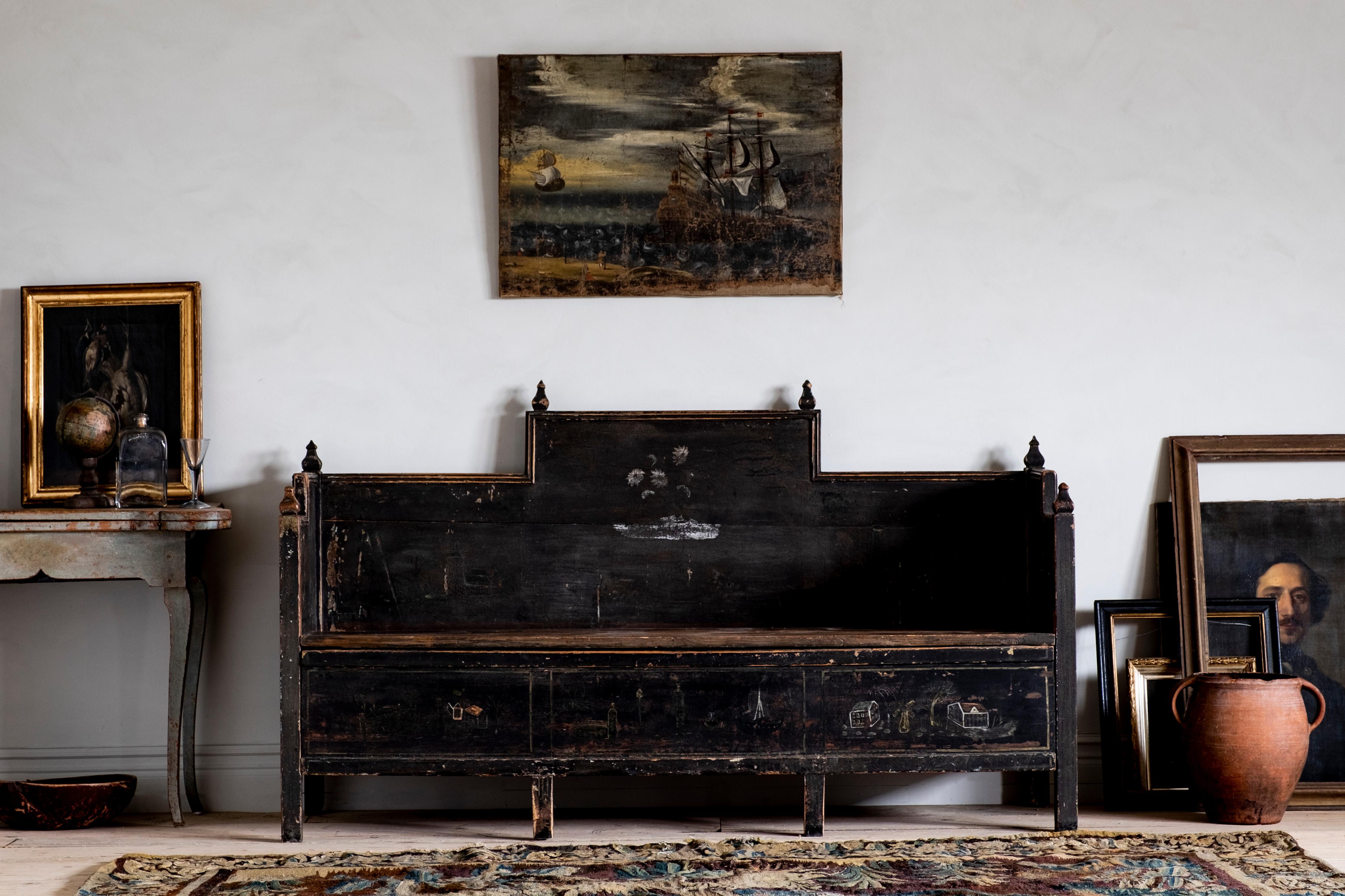 Most unusual 18th century Gustavian folk art sofa in its original black color with a good patinated surface. Wonderful naive paintings on the front and sides and the lid open for storage underneath, circa 1790 Sweden. 

The condition is good with