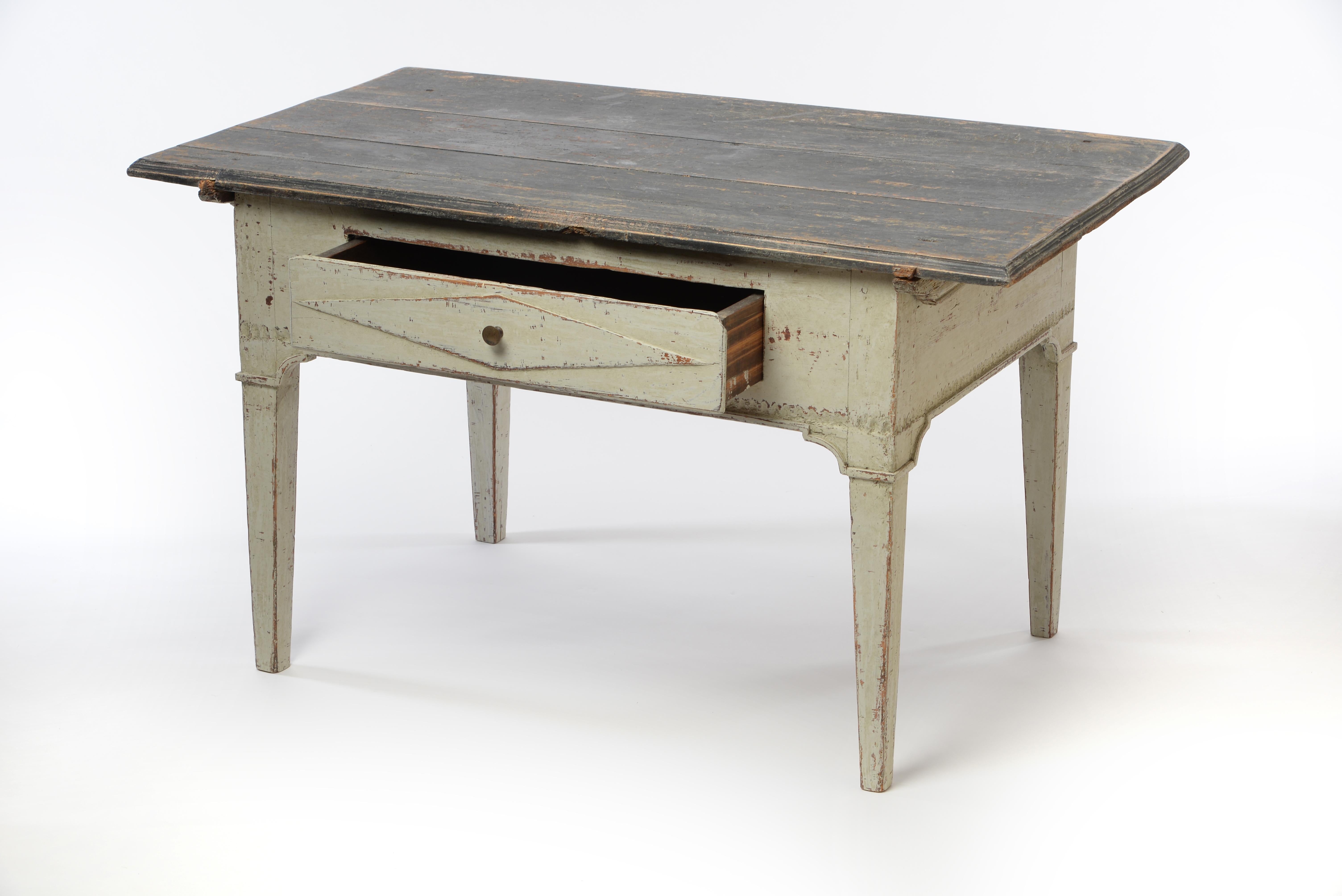 This unique Gustavian low table has a very charming appearance due to its low height, front drawer, and overlapping tabletop. The darker tabletop which is removable adds strength to the table. A wonderful piece that speaks for itself. For further