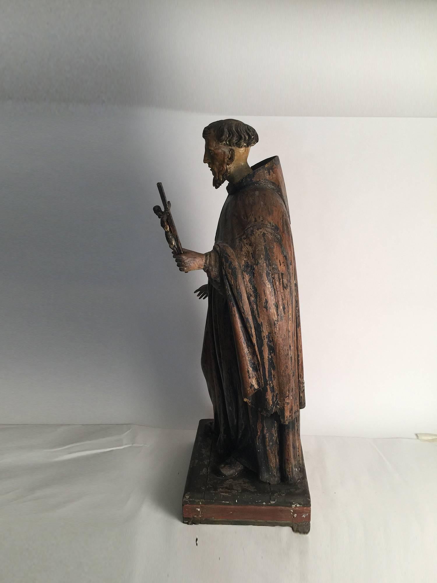 Amazing 18th century large hand carved polychrome figure of Saint Anthony. Original paint surface with some age cracks. The head and crucifix is removable. Dimensions: 38.5” H x 15” W x 12.5