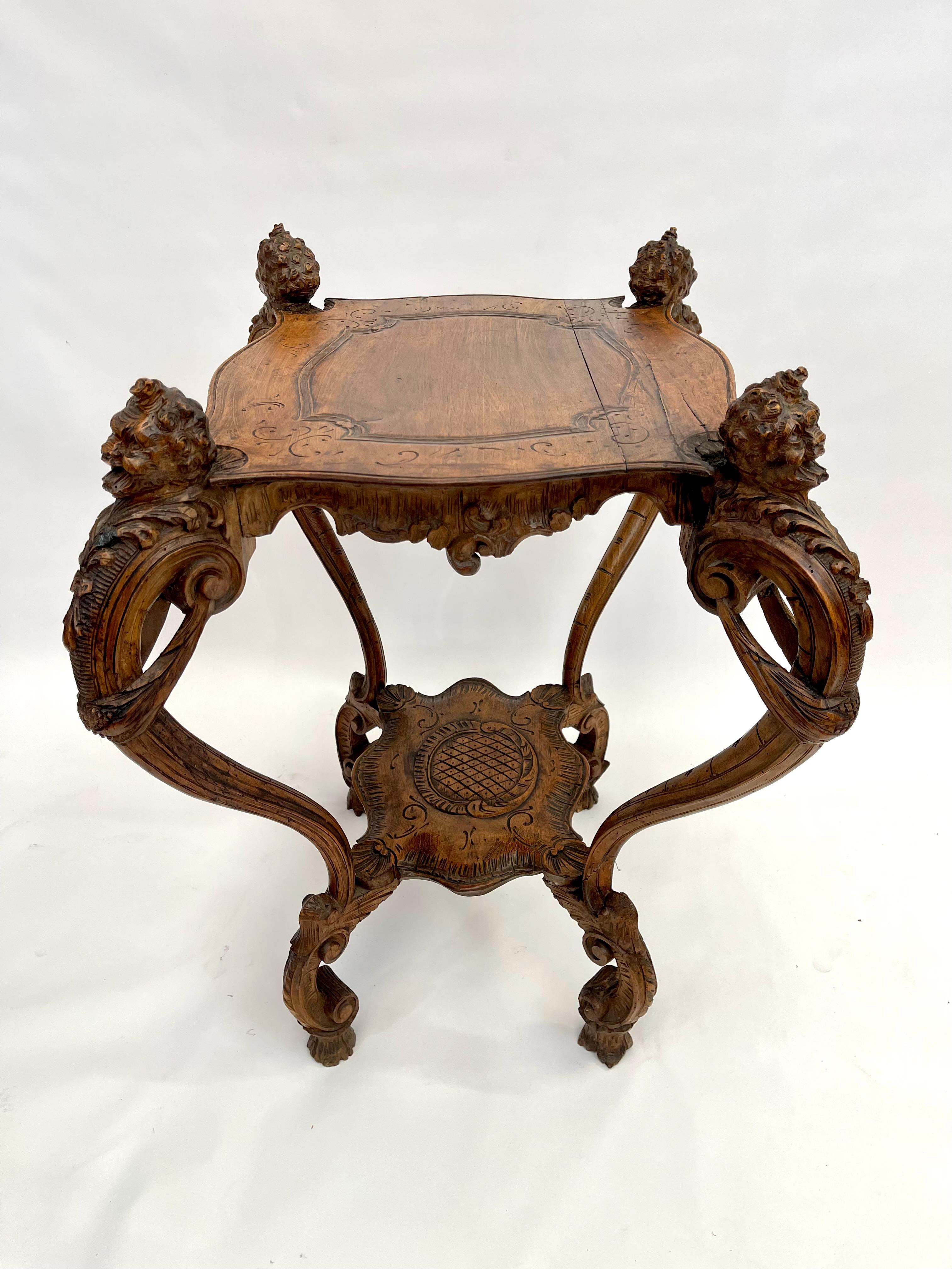 Antique 18th Century Violin-Shaped Center Table console with Carved Natural Wood Apron Shelf.
At each corner of the table, there is a sculpted head.
The entire piece is beautifully crafted and sculpted.
18th-century Baroque tables were often