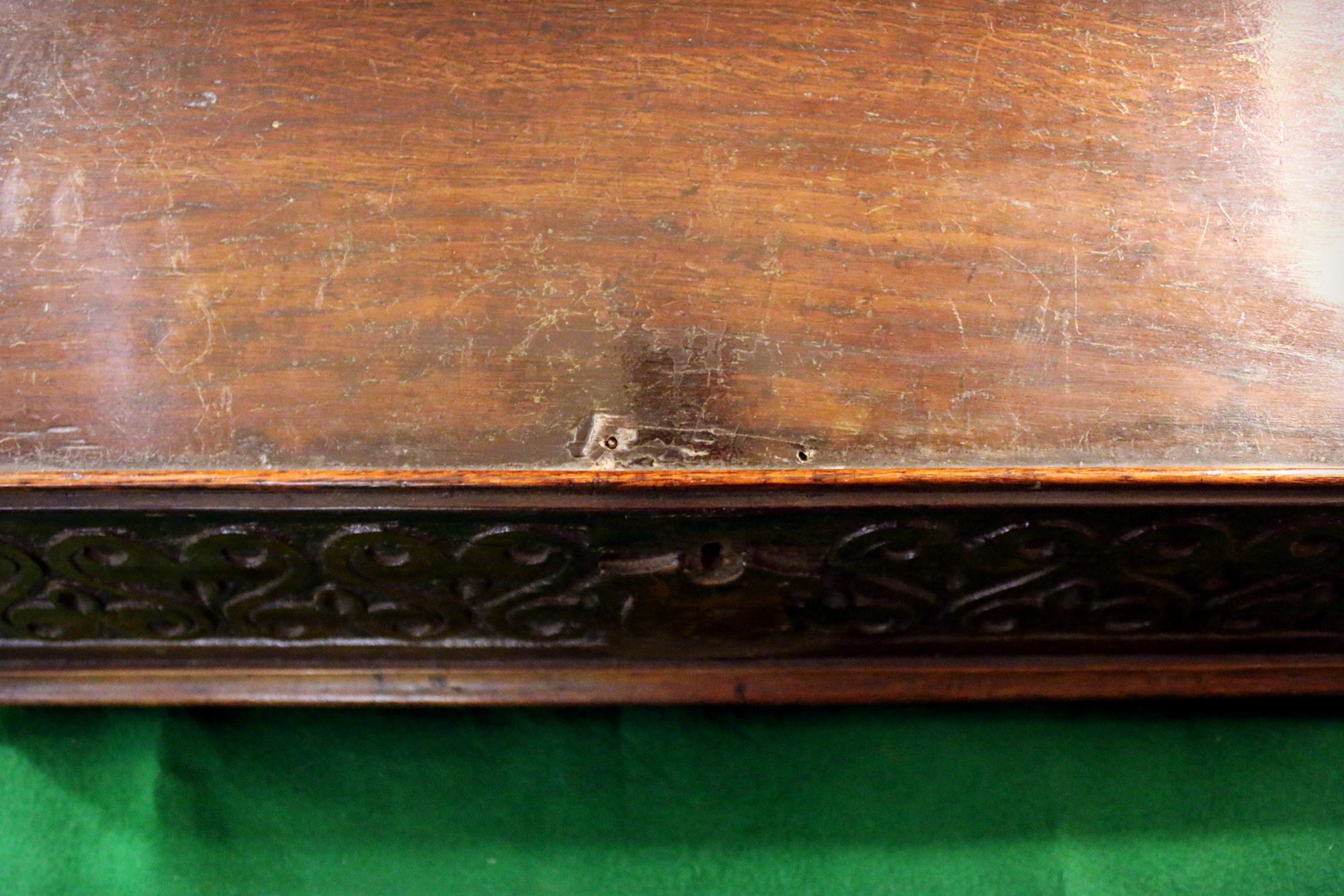 English Bible box or writing box of solid oak with hand carved design and shield in front. Slant top with ledge feature on the inside. Bun feet.
Remnants of paper on the underside of the lid.
See measurements below.