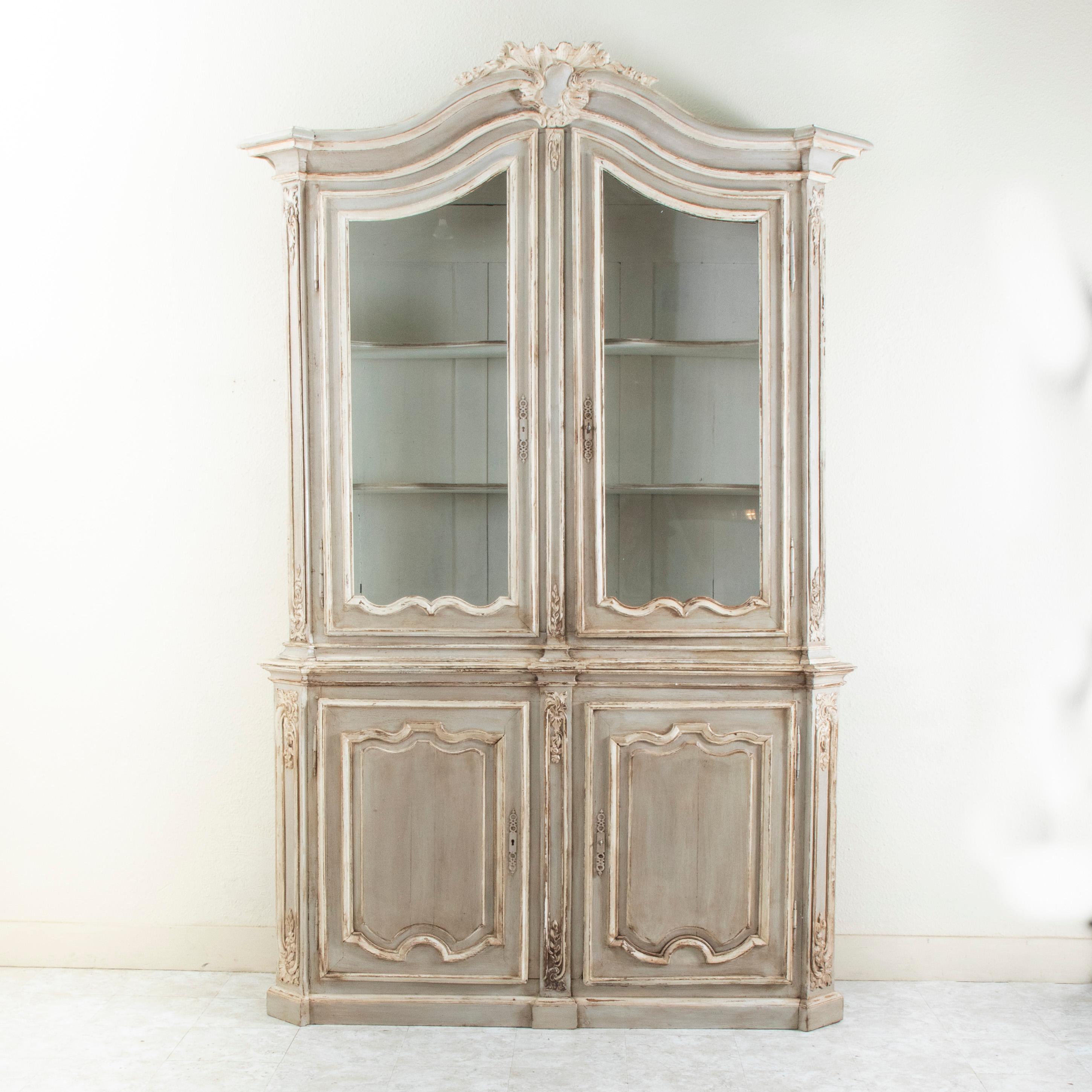 D'une hauteur impressionnante de 106 pouces, ce buffet deux corps d'époque Régence française du XVIIIe siècle provenant d'un château de Liège, en Belgique, présente des détails sculptés à la main tels qu'un cartouche festonné asymétrique au niveau