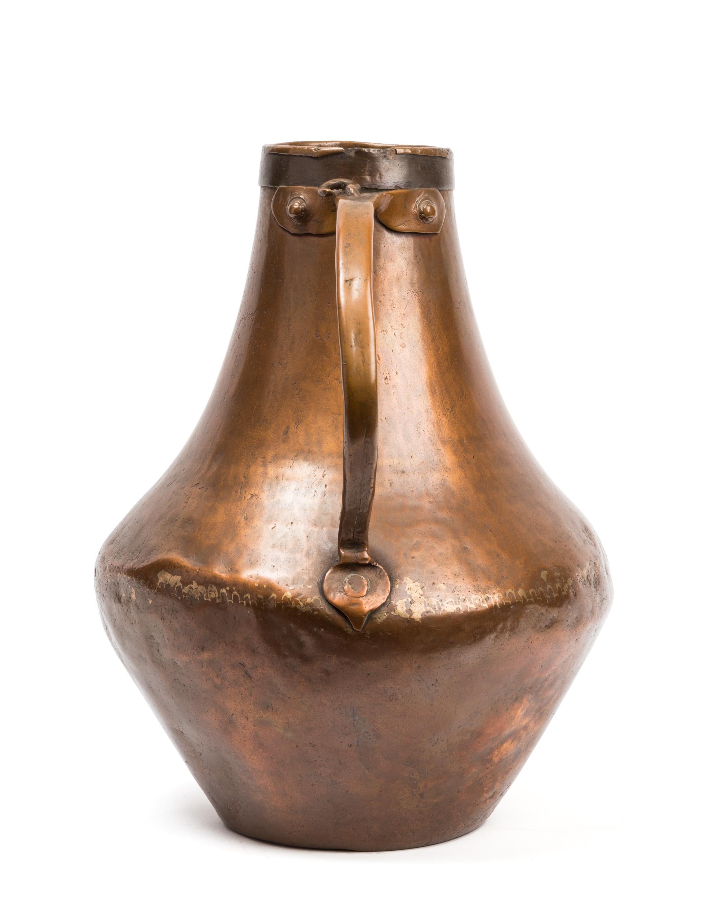 Hammered, riveted and soldered in 18th century Spain, this copper container was made for common household use, but with its sculptural form, rich color and patina of age it surpasses its rough beginnings to become a thing of beauty. The handle is