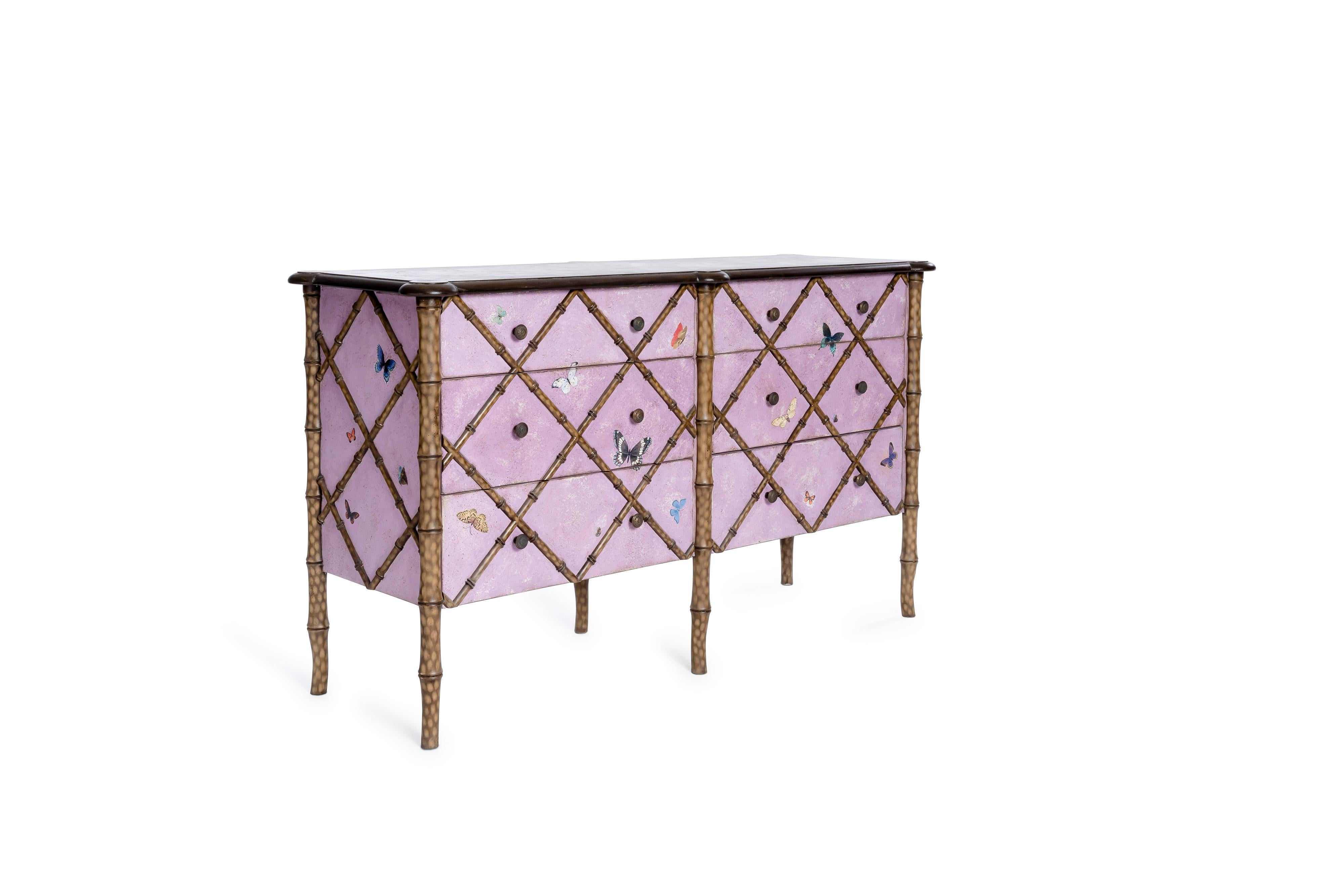 De notre Collection de meubles peints à la main, nous avons le plaisir de vous présenter notre Commode double Fiesole en bambou rose avec décor de papillons. 
Cette pièce éclectique apportera la bonne dose de fantaisie à votre pièce, ainsi que