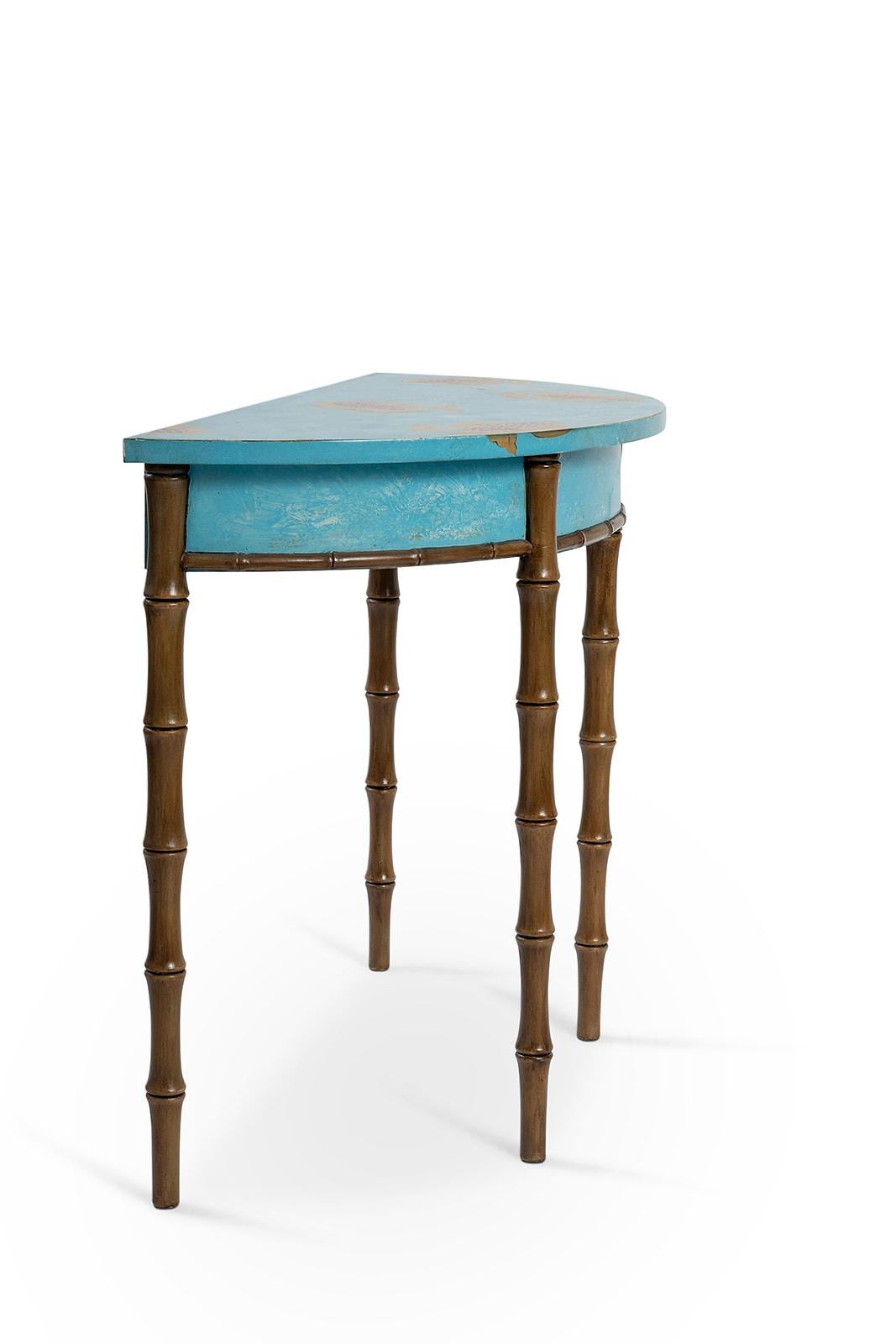 From our hand-painted Furniture Collection, we are pleased to introduce you to our bamboo Ravenna Demilune. 
Finished in electric blue with sweet pomegranates decors, completed with gold-leaf details, this eclectic demilune will surely add that