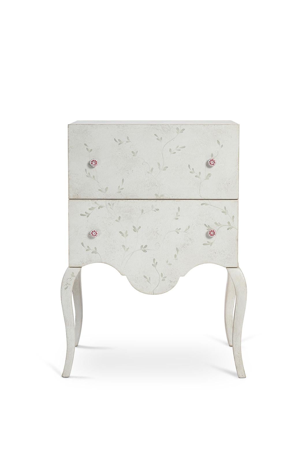 From our hand-painted furniture collection, we are pleased to introduce you to our beautiful Brenta Nightstand with hand-painted subdue blue branches and small leaves decor.

Inspired by a feminine and minimal mood, the pink metal pulls and the