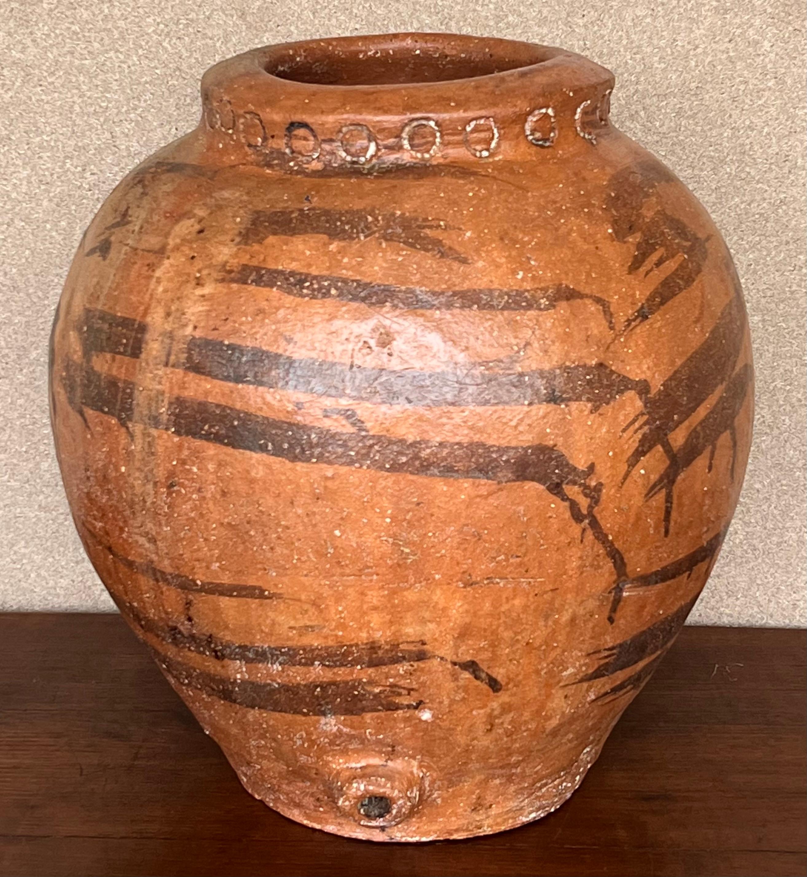 This is a terracotta olive jar from central Spain. It has a wonderful aged patina with chalky painted finish. It makes a great statement as a sculpture in a room on a pedestal, alone or with a plant. Stamped on the pot and two handmande