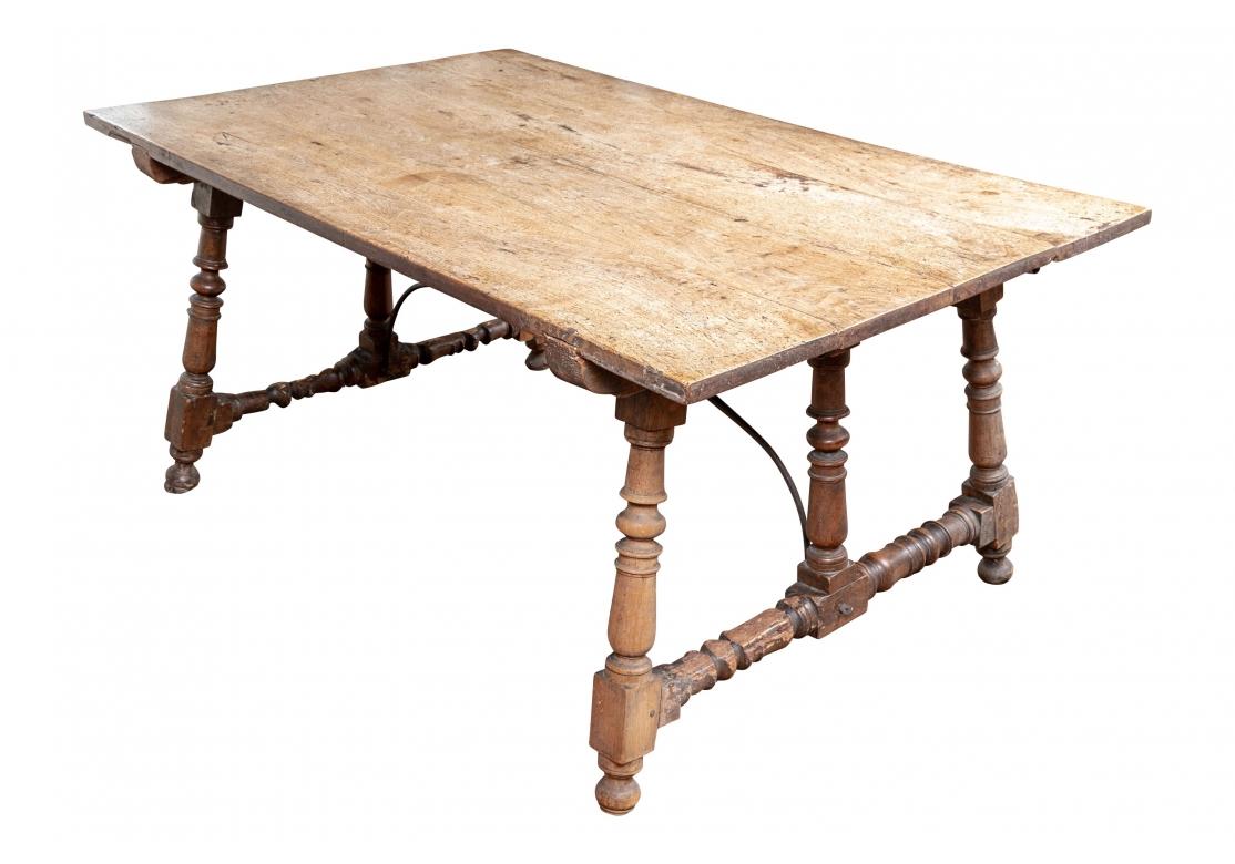 Late 17th or Early 18th century hardwood top Tavern  table having a magnificent traditional form. The table has two later hand-fashioned Oak extension boards and an arched and sinuous iron stretcher. The table with planked boards and triple turned